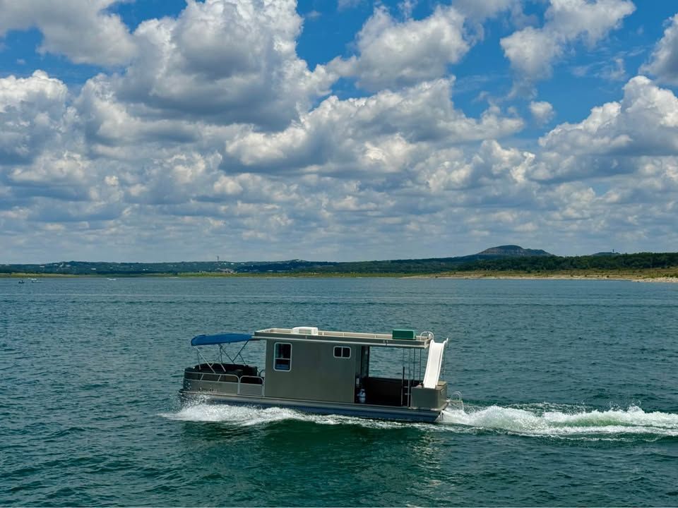 2008 Sun Tracker Party Cruiser on a lake under cloudy skies.