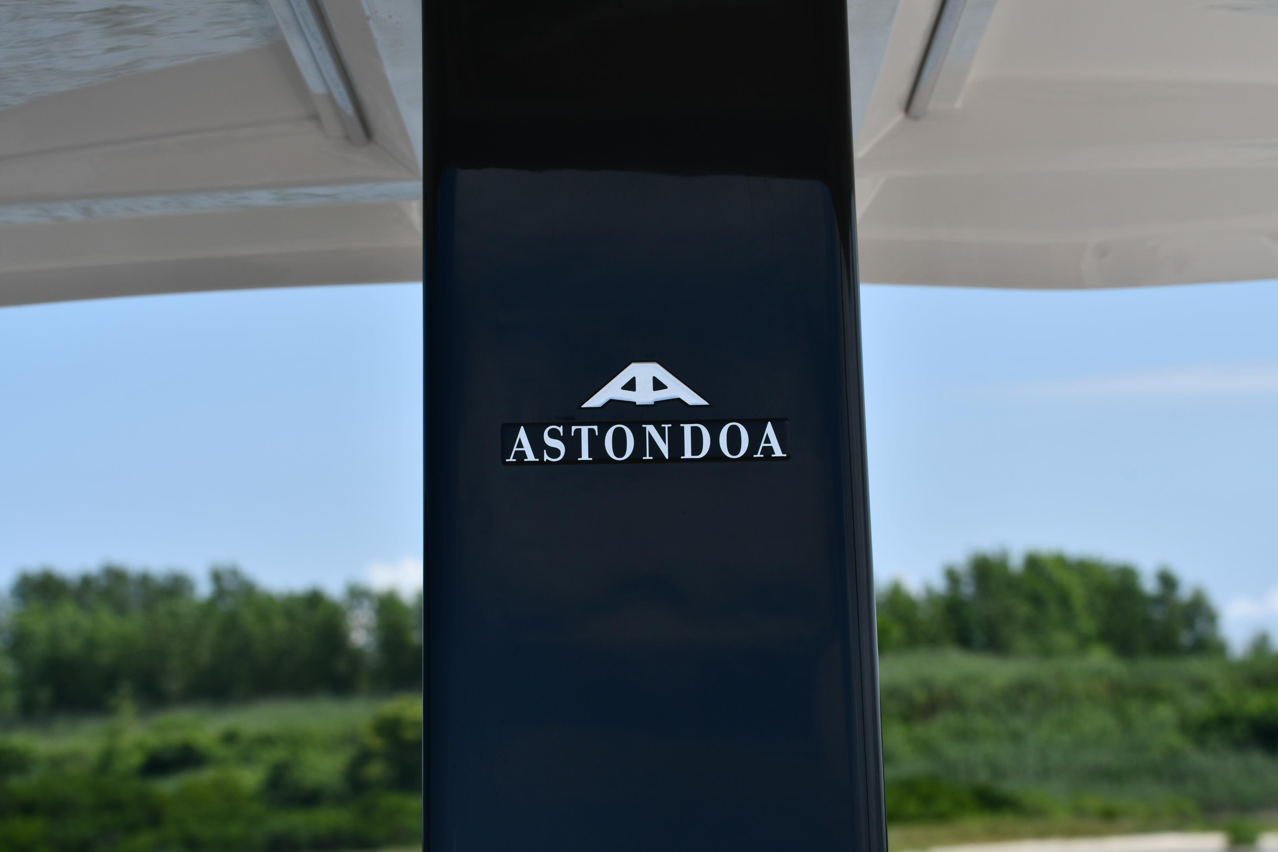 Astondoa 377 Coupe Outboard 2023 logo on sleek black surface, outdoor background.