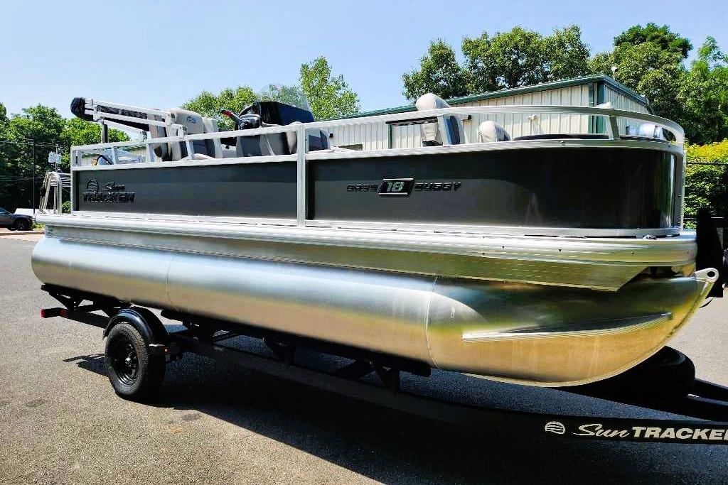 2026 Sun Tracker Bass Buggy 18 DLX pontoon boat on trailer, parked outdoors.