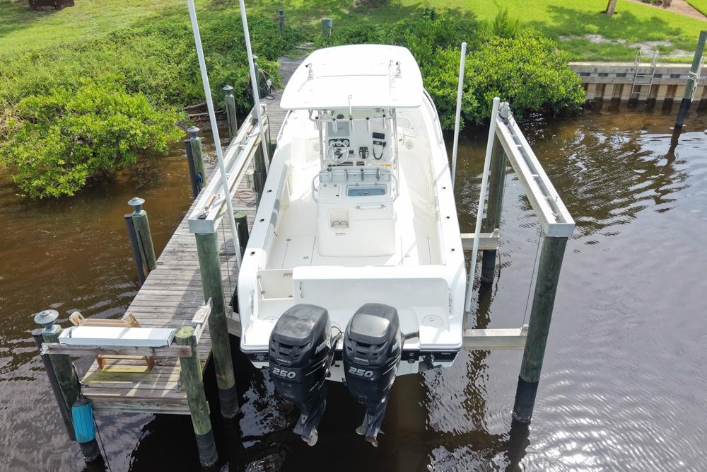 2018 Mako 284 Center Console boat docked with dual engines, aerial view.