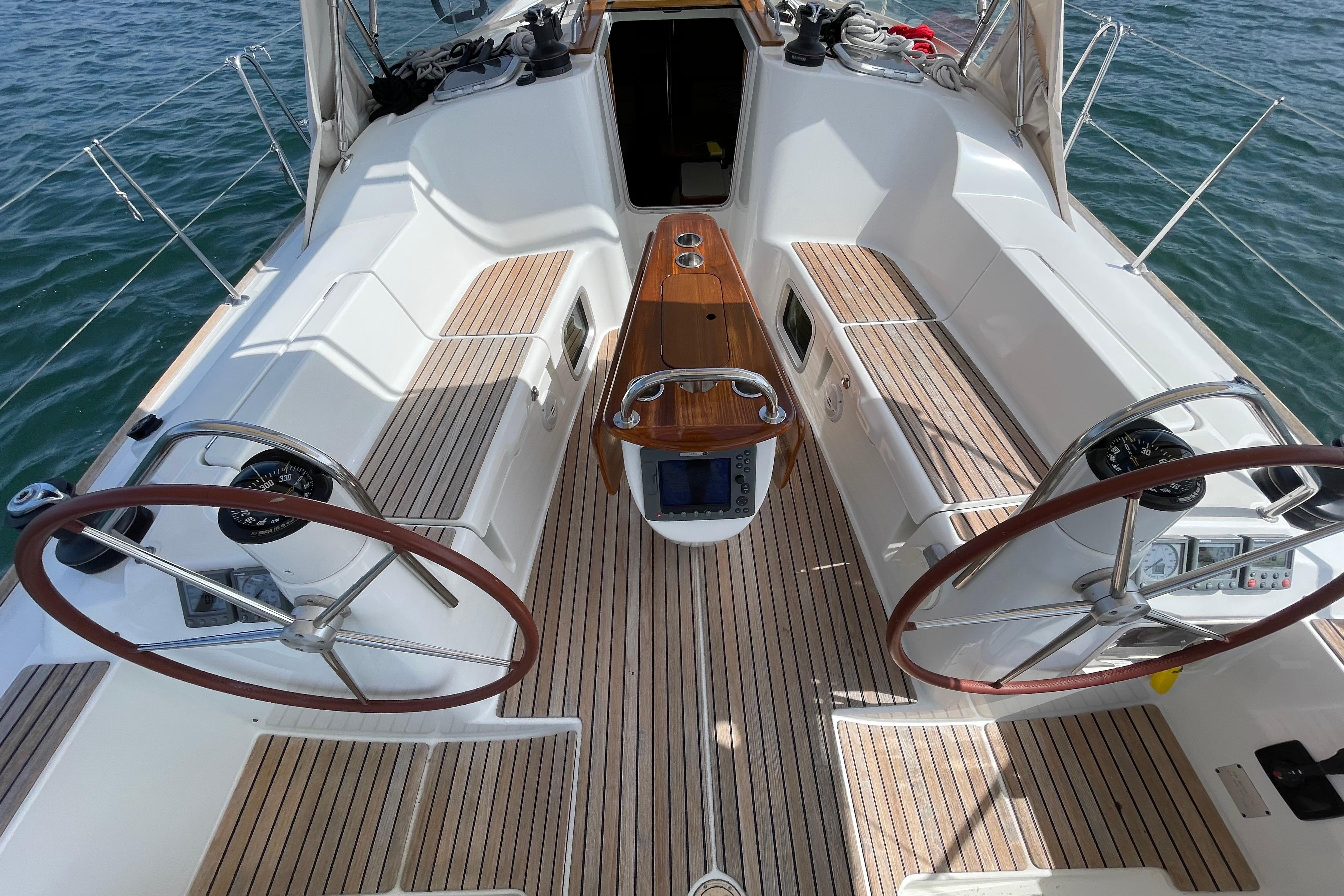 Cockpit of 2007 Jeanneau Sun Odyssey 39 DS sailboat with dual steering wheels and teak flooring.