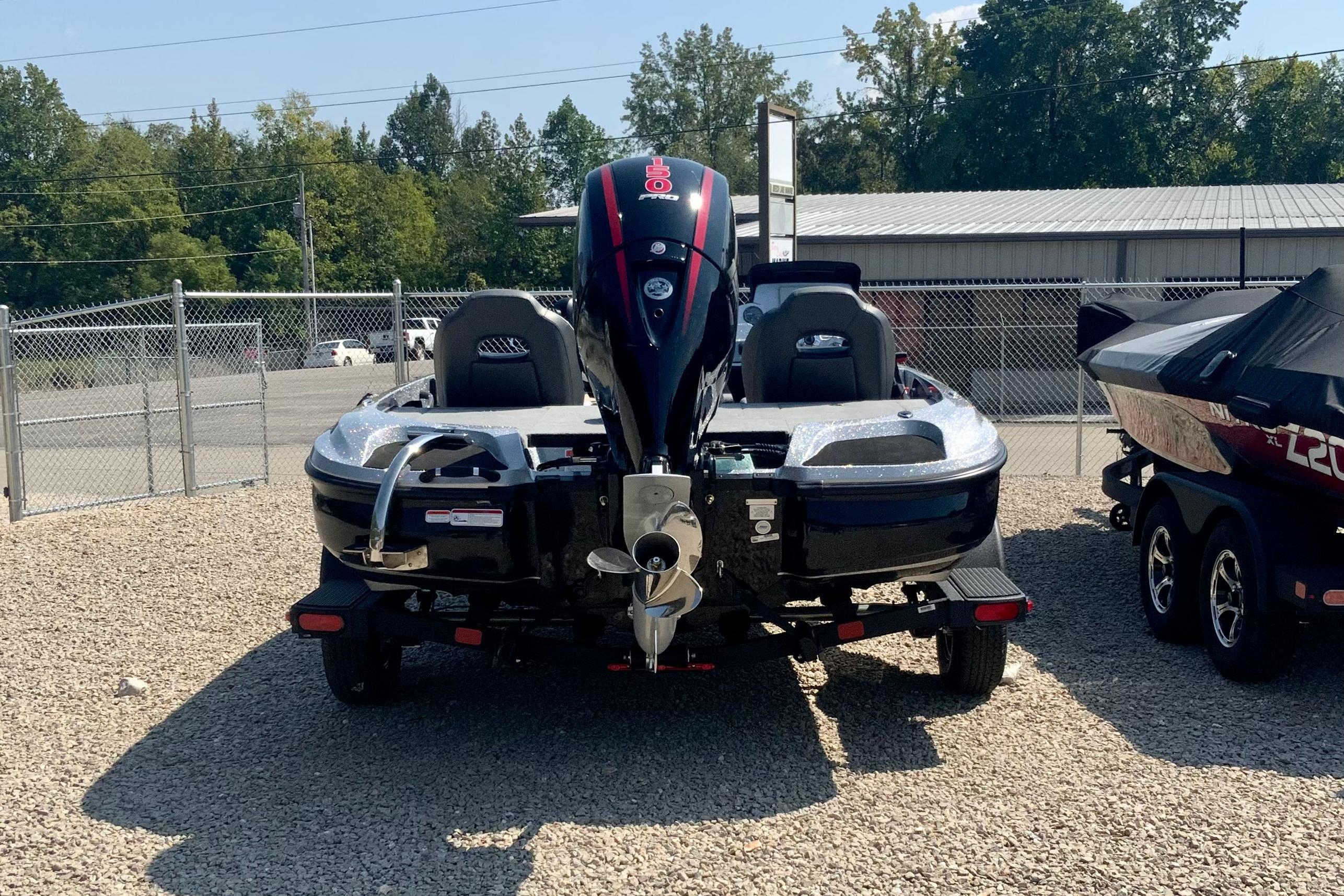 2026 Nitro Z18 Pro boat on trailer, parked on gravel lot, rear view.
