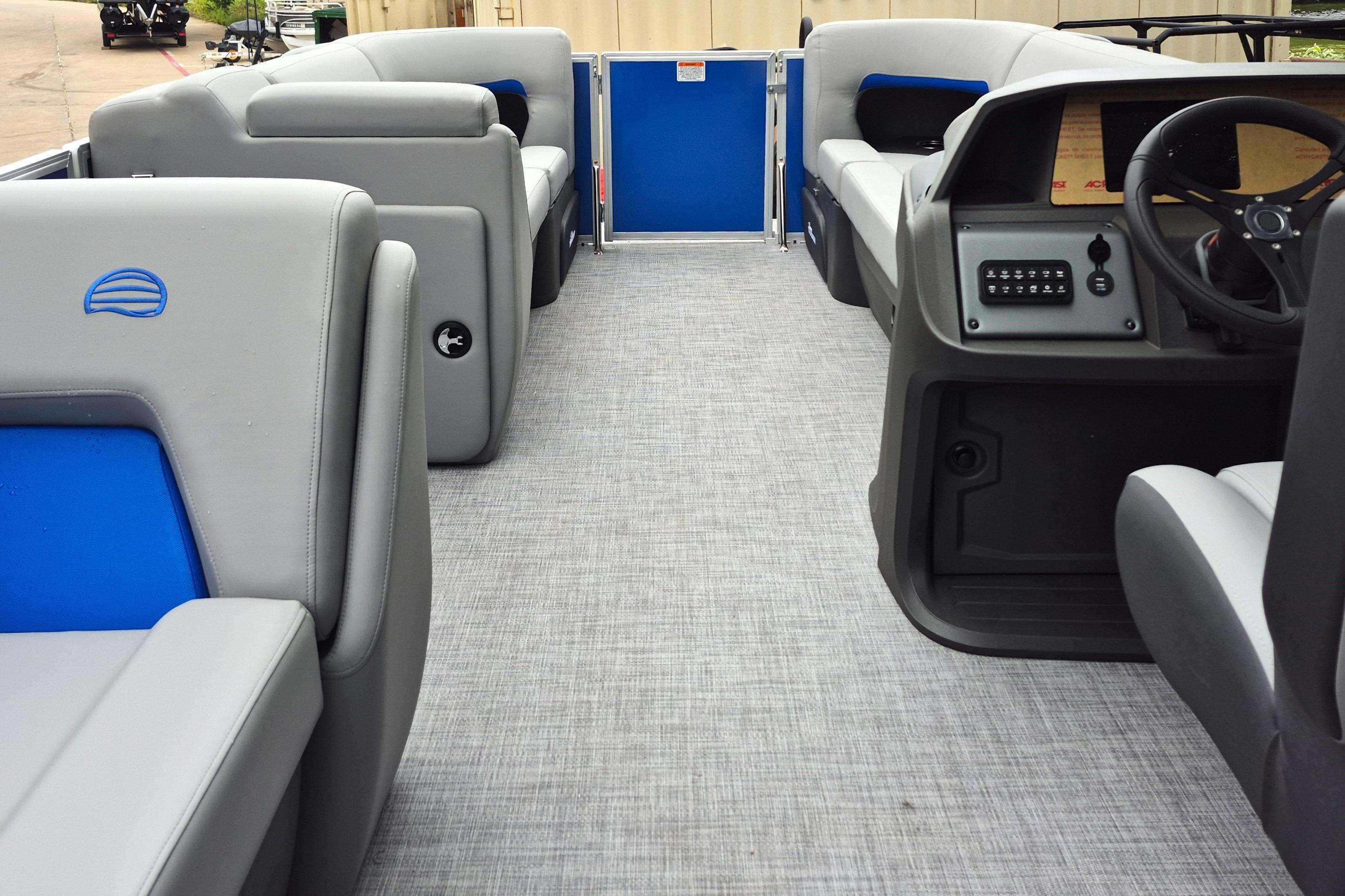 2026 Sun Tracker Party Barge 20 DLX interior with gray and blue seating, modern dashboard.
