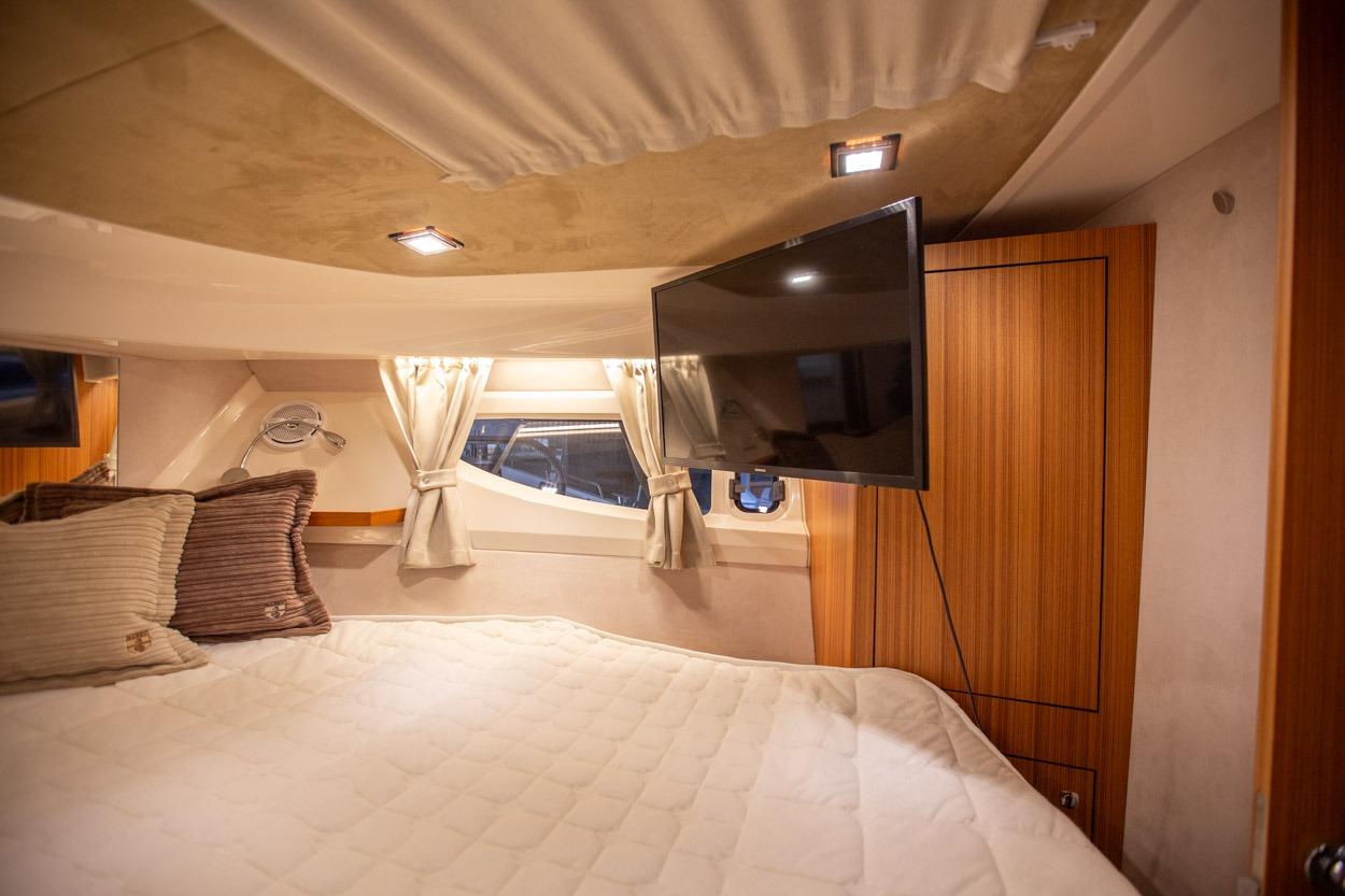 Luxurious cabin interior of 2022 Marex 360 Cabriolet Cruiser with cozy bedding and TV.