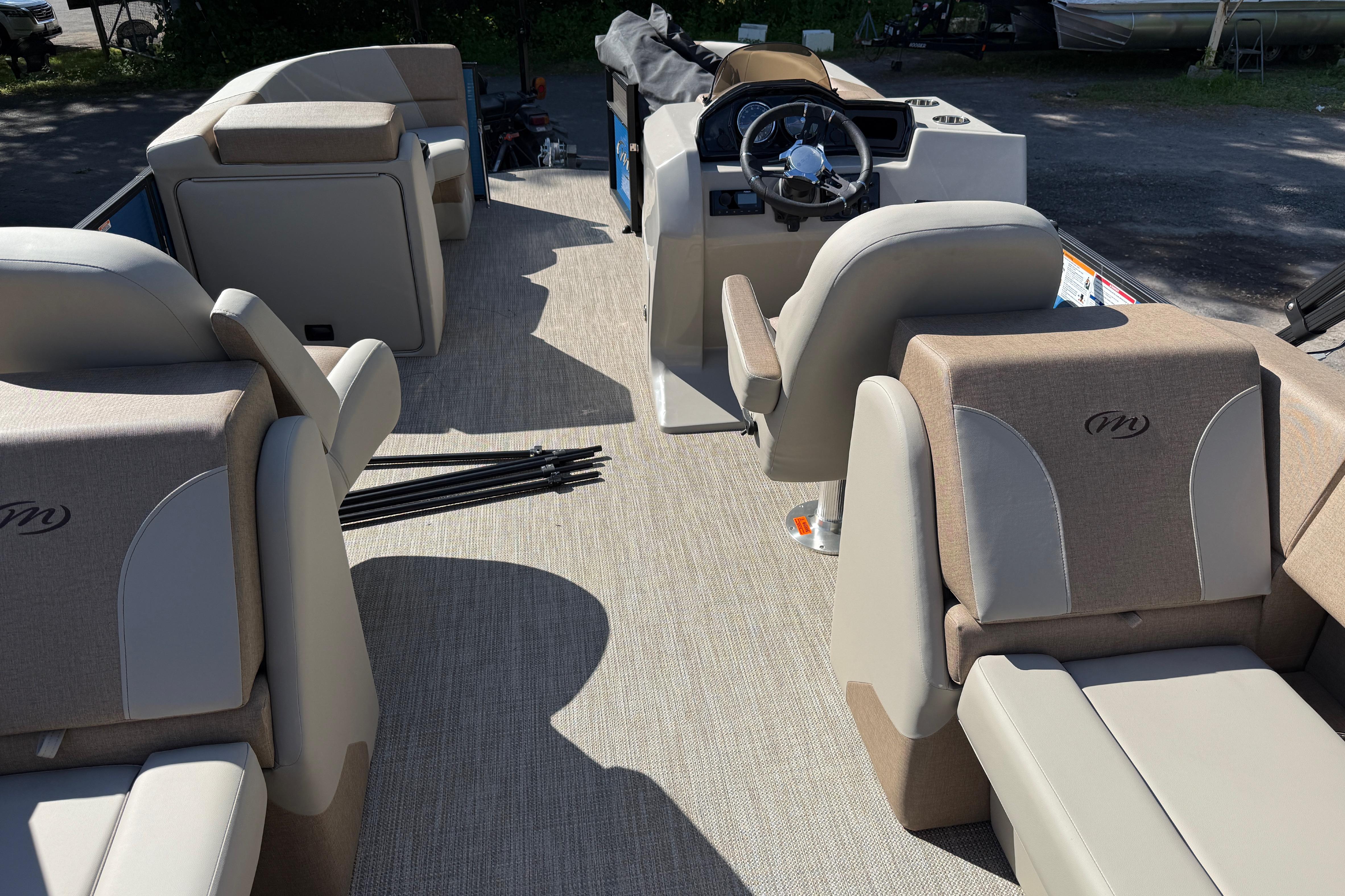 Interior view of 2027 Manitou Aurora RF 23 pontoon boat with beige seating and steering console.