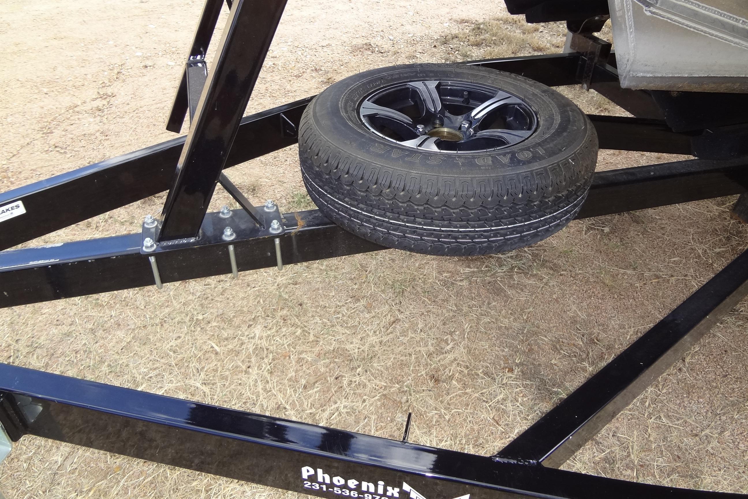 2024 Tahoe Pontoon 2585 VRL trailer with spare tire on dry grass.