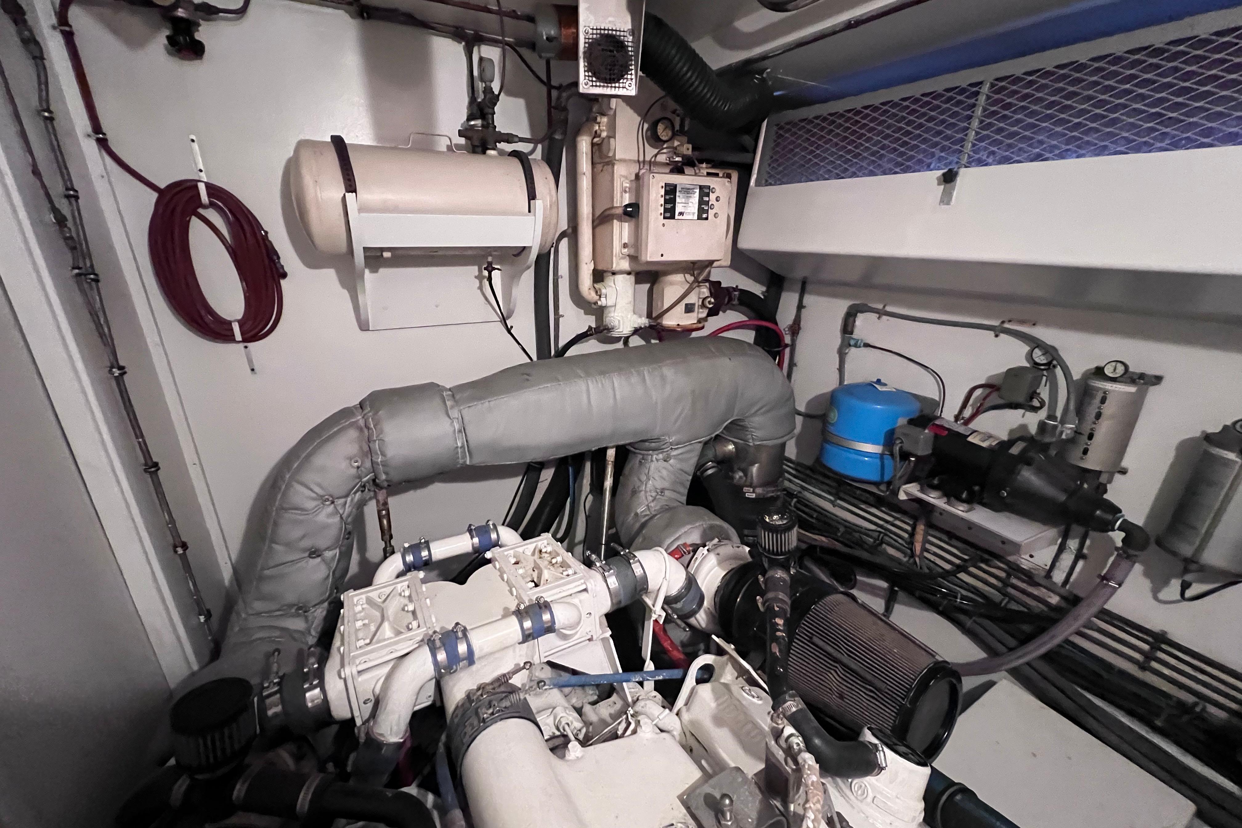 Engine room of 1987 Hatteras 70 Cockpit Motor Yacht, showcasing mechanical components.
