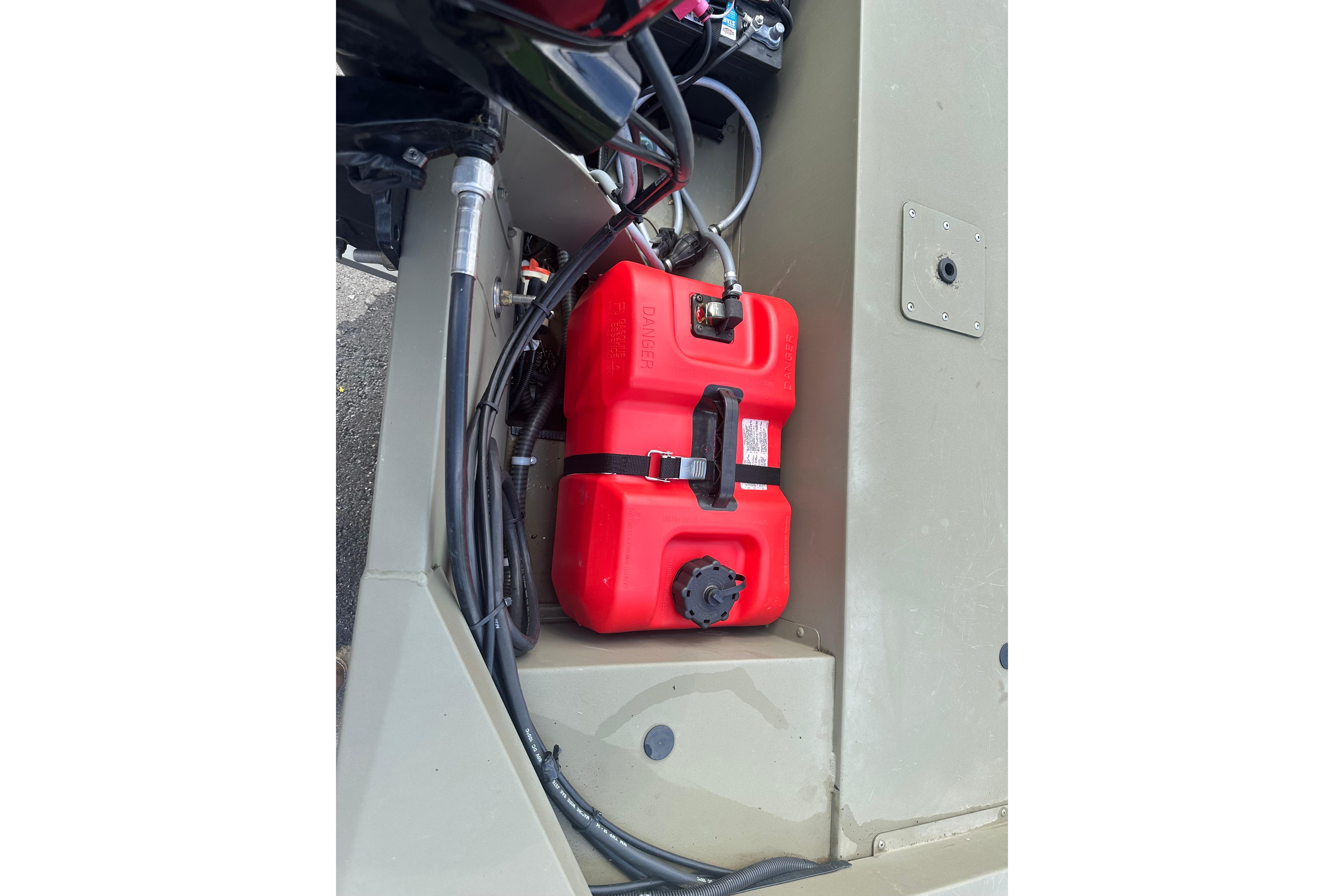 Red fuel tank in 2024 Tracker Grizzly 1648 SC boat's storage compartment.