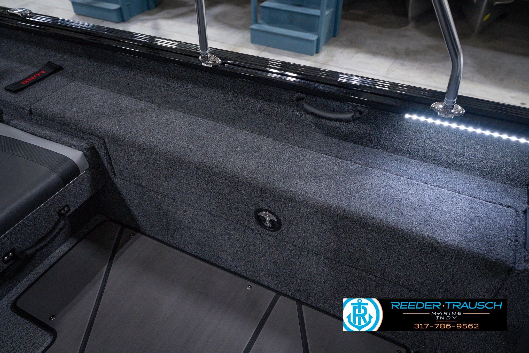 2026 Lund 1875 Impact XS SS boat interior with LED lighting and carpeted storage.