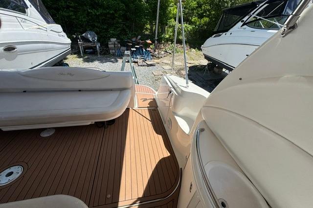 2002 Sea Ray 360 Sundancer boat deck with seating, docked near other boats.