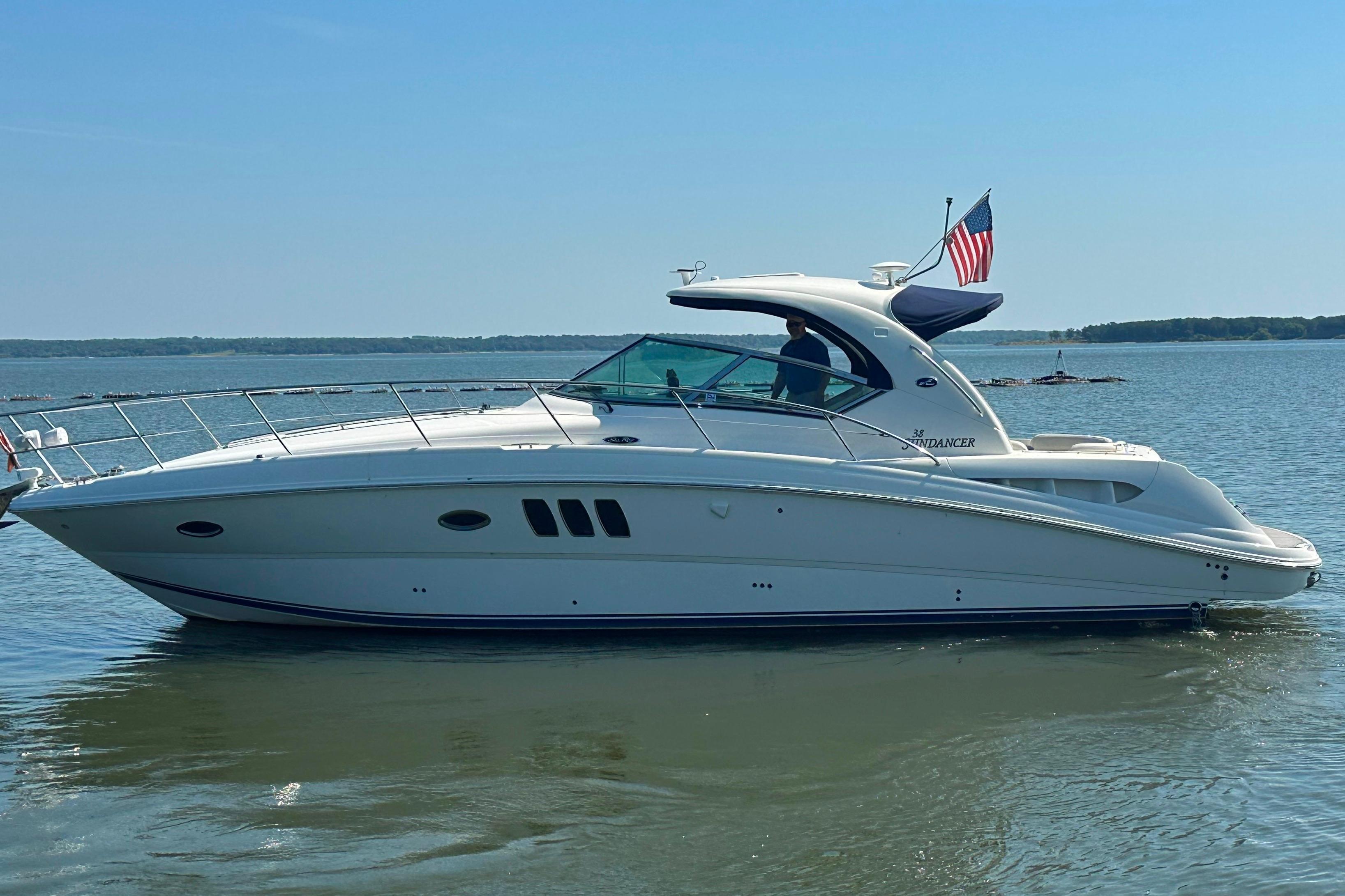2007 Sea Ray 38 Sundancer yacht on calm water with American flag.