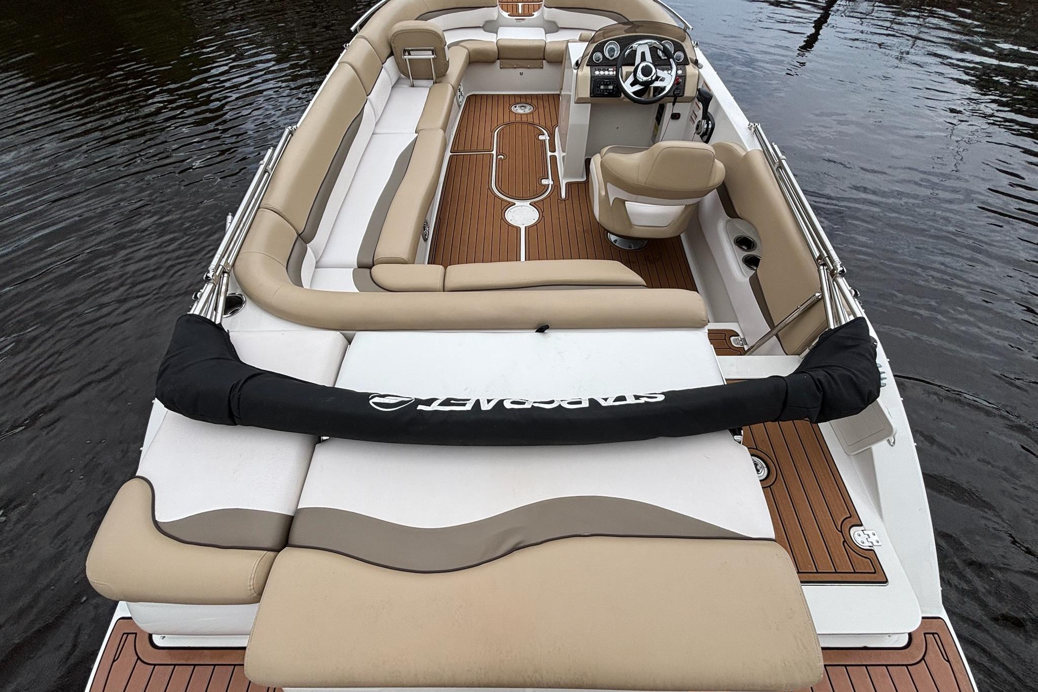 2017 Starcraft Star Step 221 I/O boat with beige seating and wood accents on water.