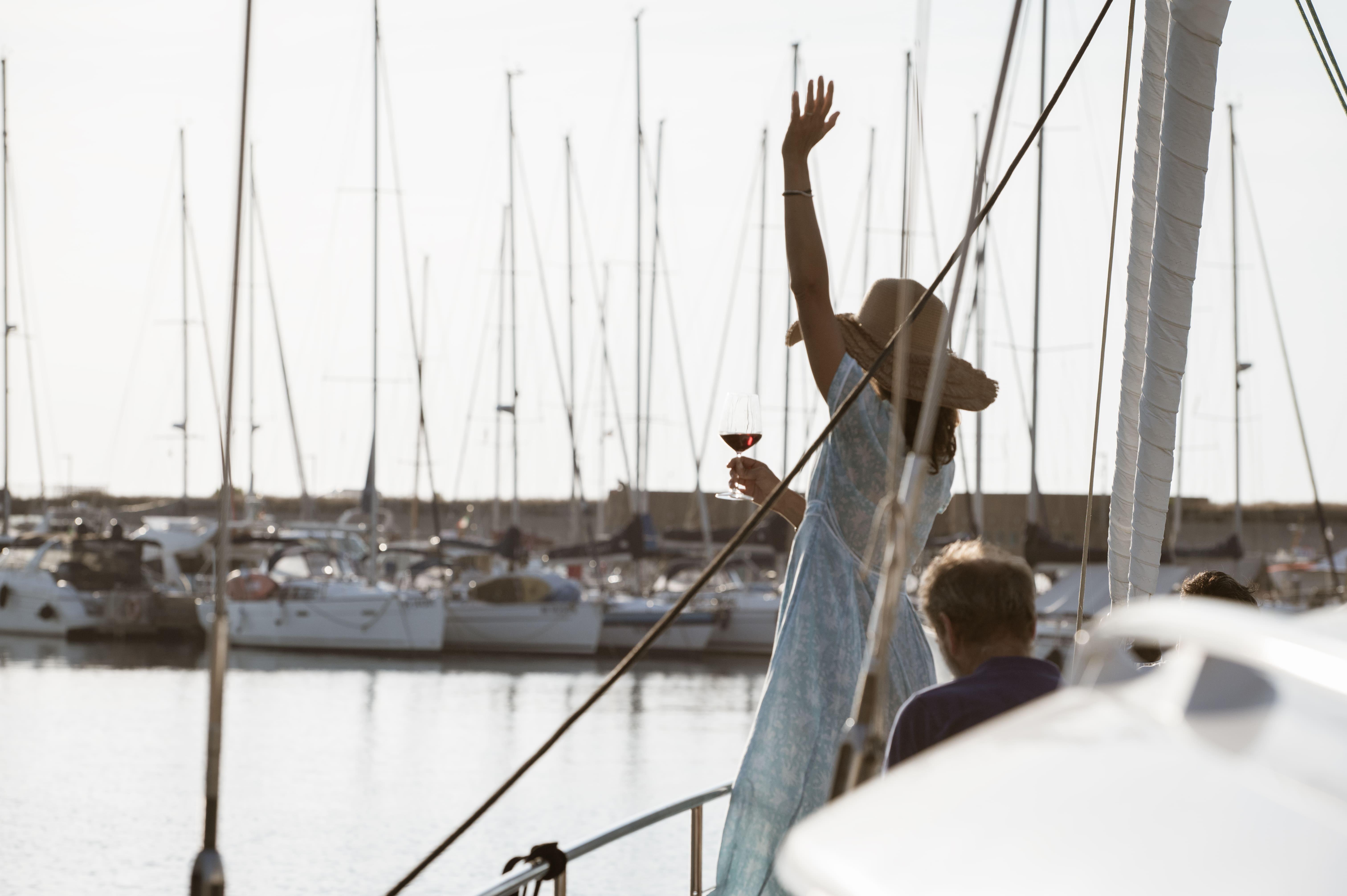 Woman enjoying on Moody Decksaloon 54 yacht, 2016, in marina with sailboats.