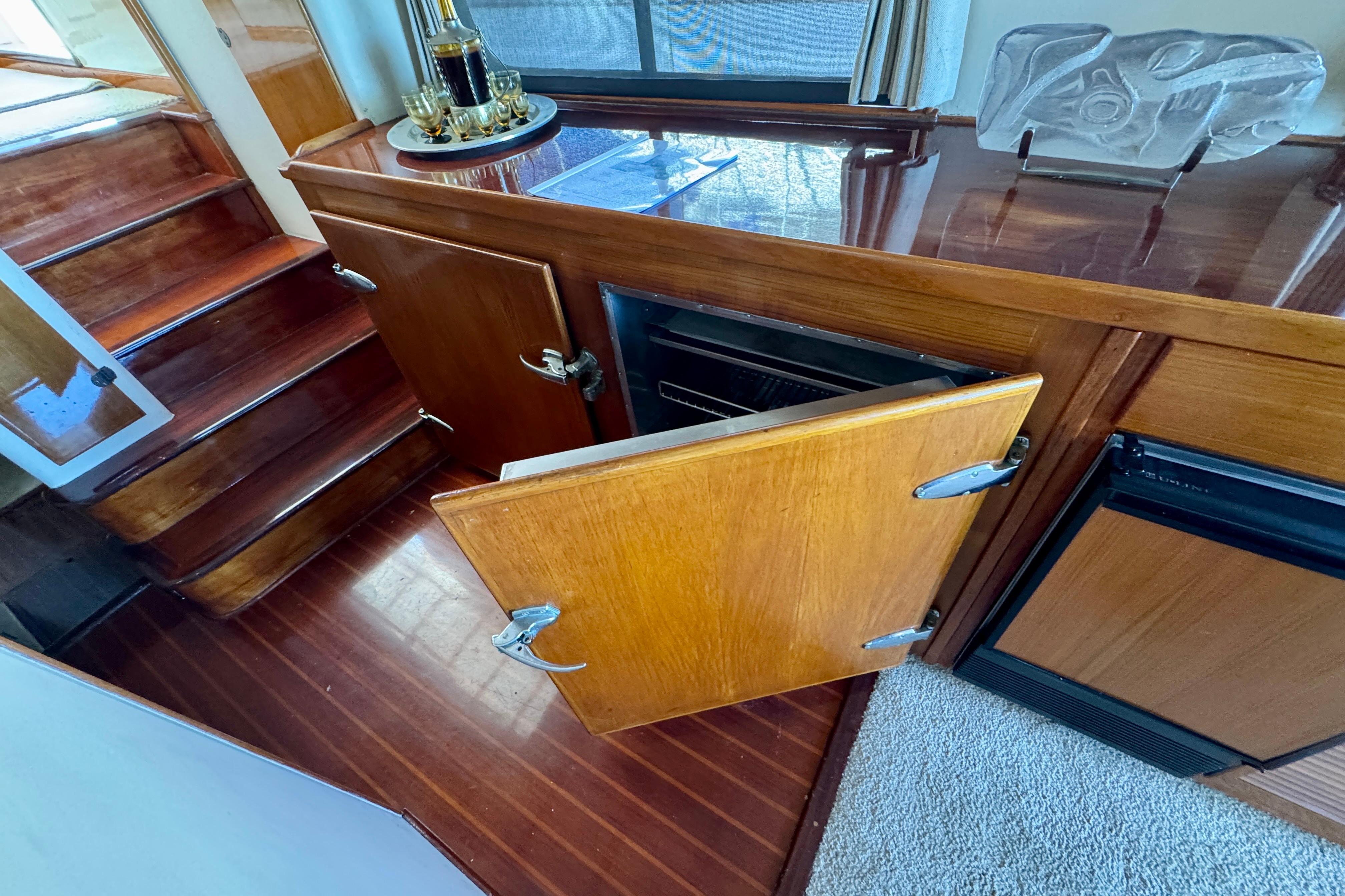 1958 Blanchard Pilothouse interior with wooden cabinetry and open storage compartment.