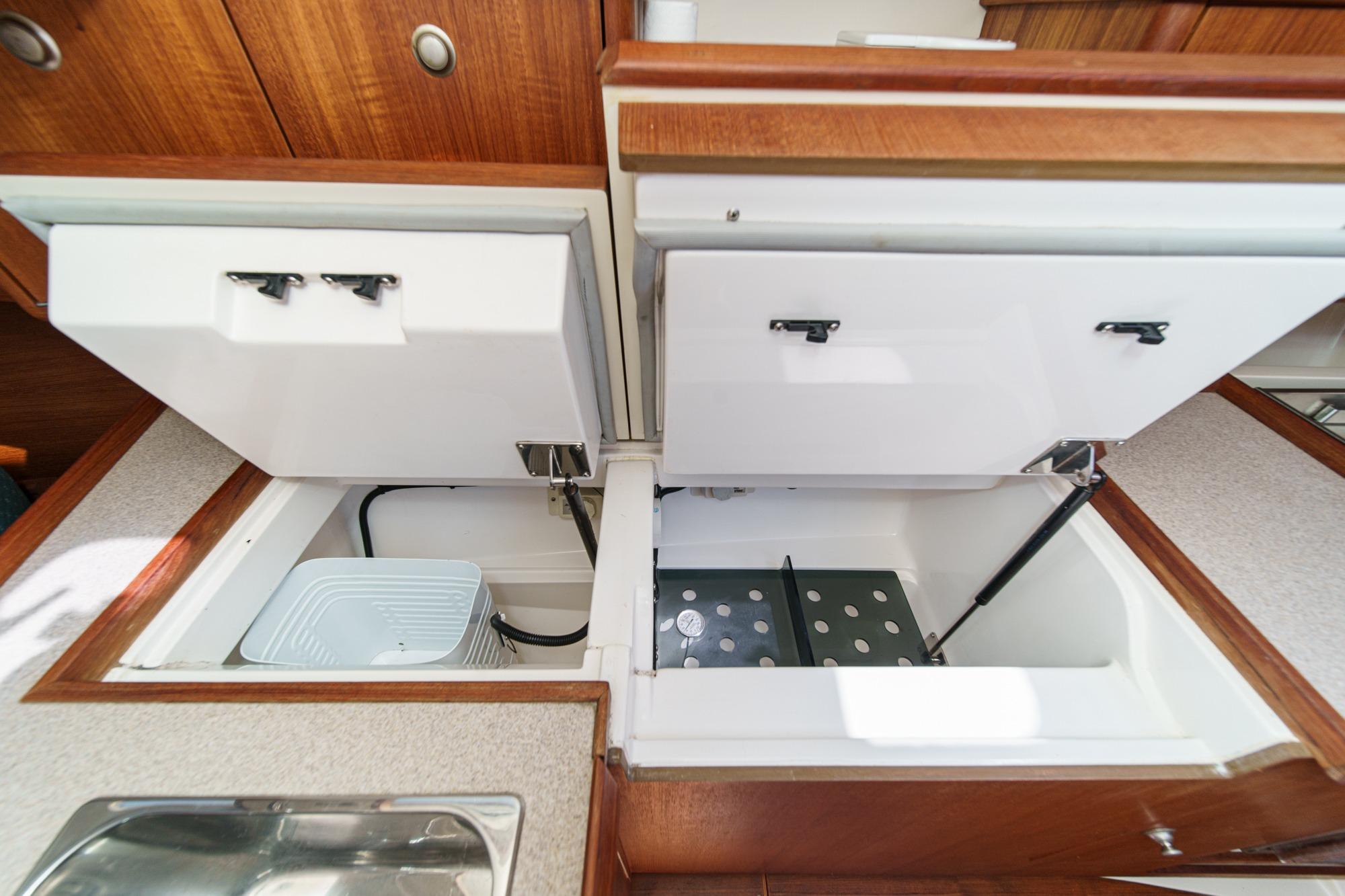 Interior view of a 1996 Hunter 376 yacht kitchen with open storage compartments.