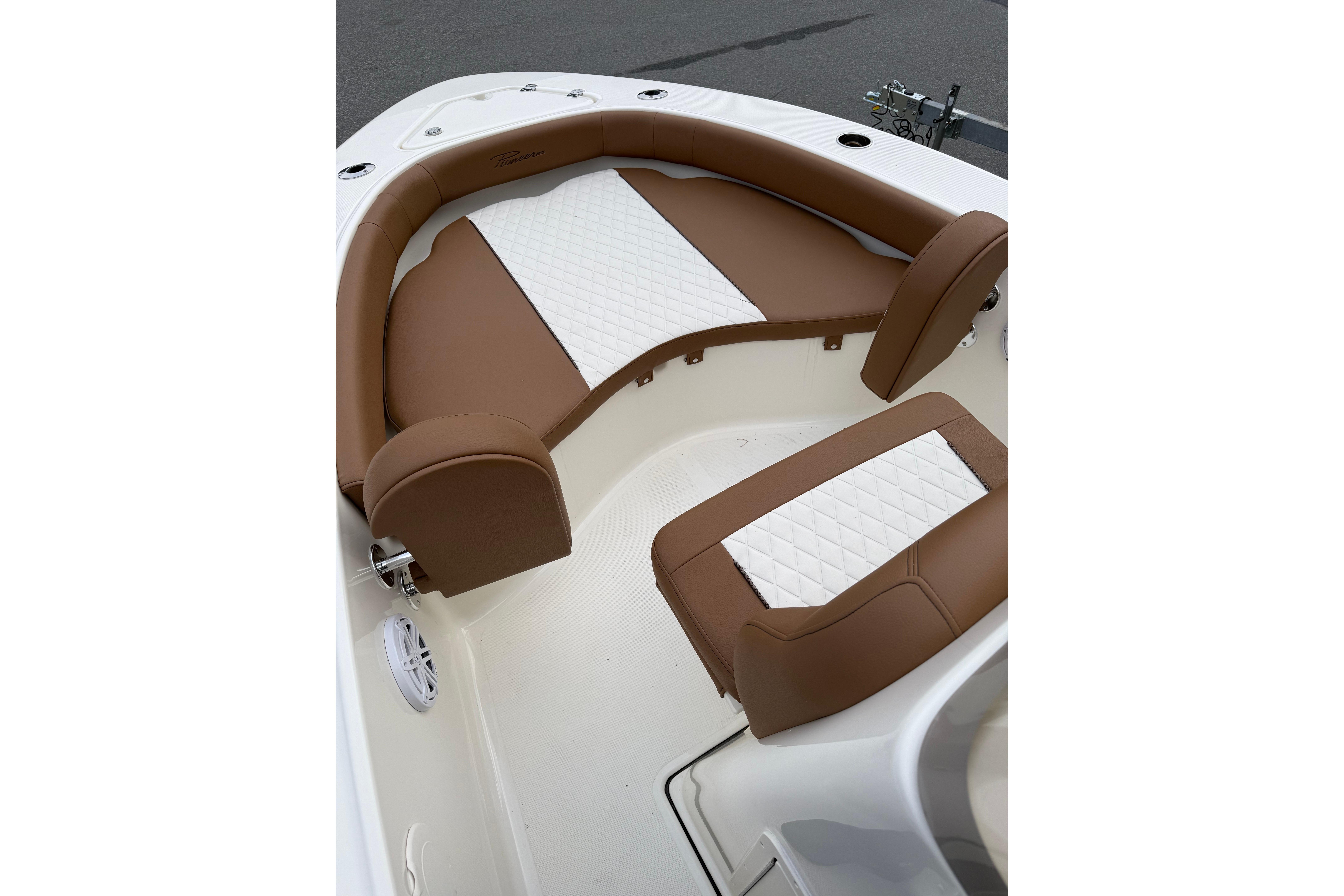 2026 Pioneer 180 Islander boat interior with brown and white cushioned seating.