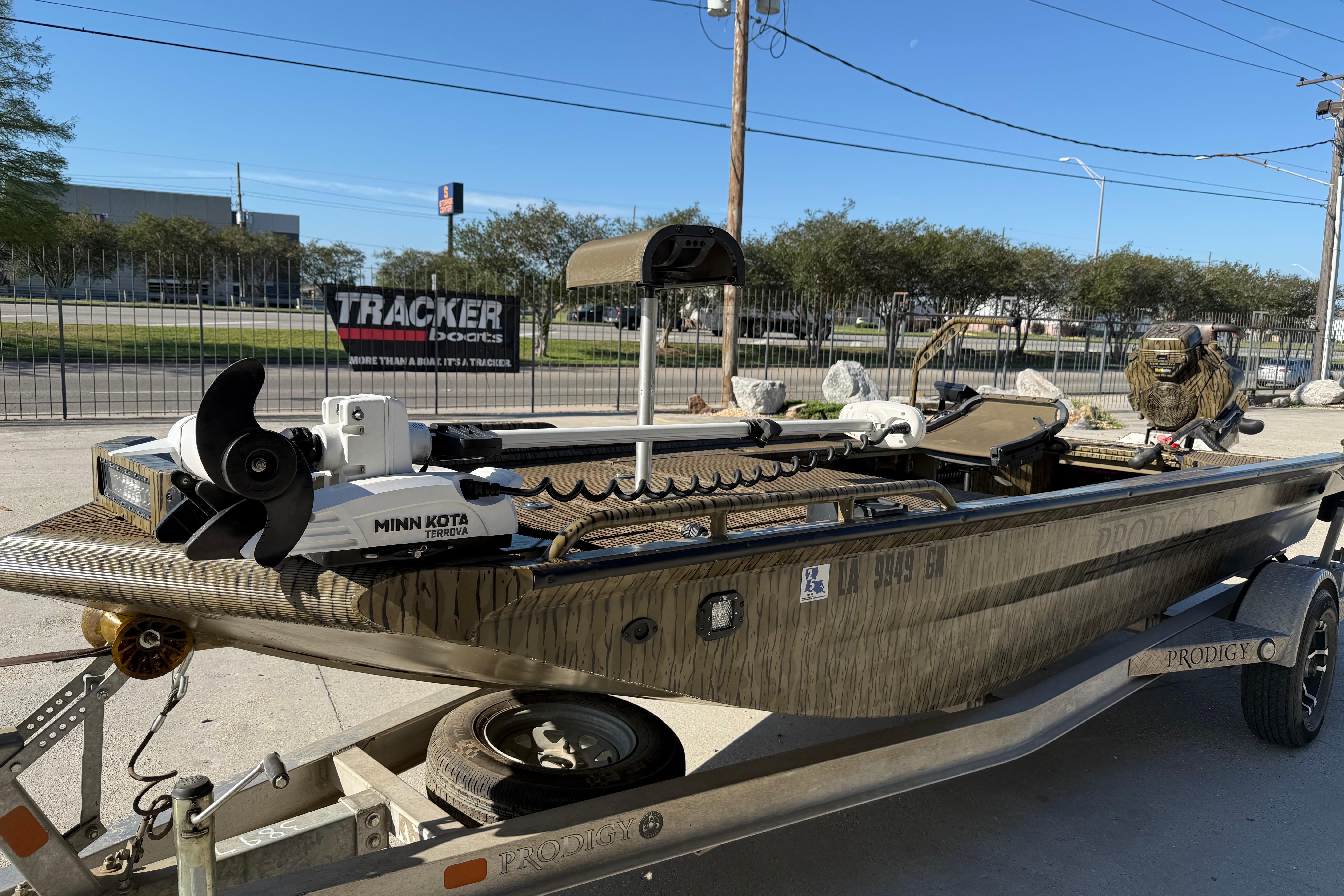 2022 Prodigy 1854 boat with Minn Kota motor on trailer, parked outdoors.