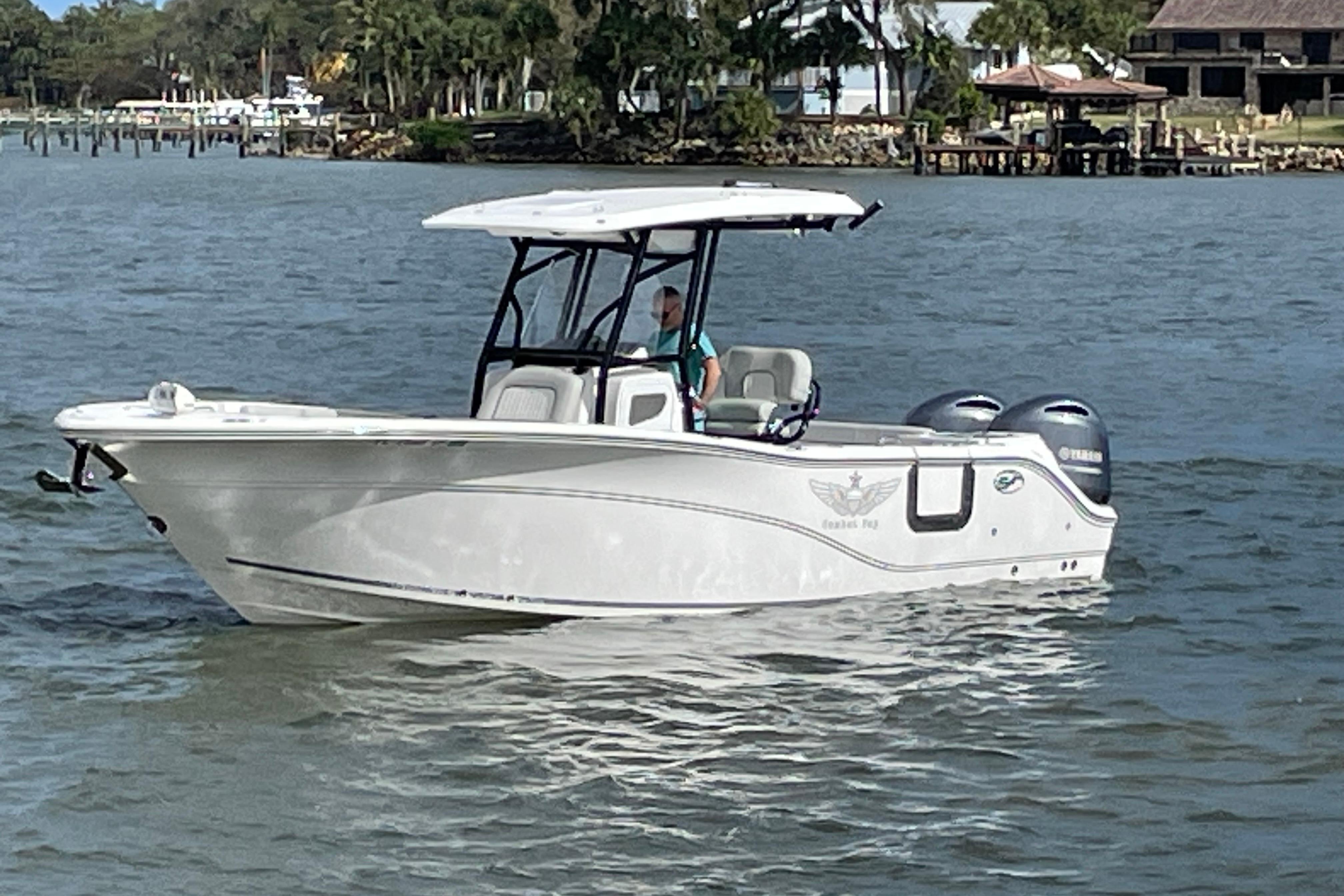 2023 Sea Fox 268 Commander boat cruising on a calm waterway.