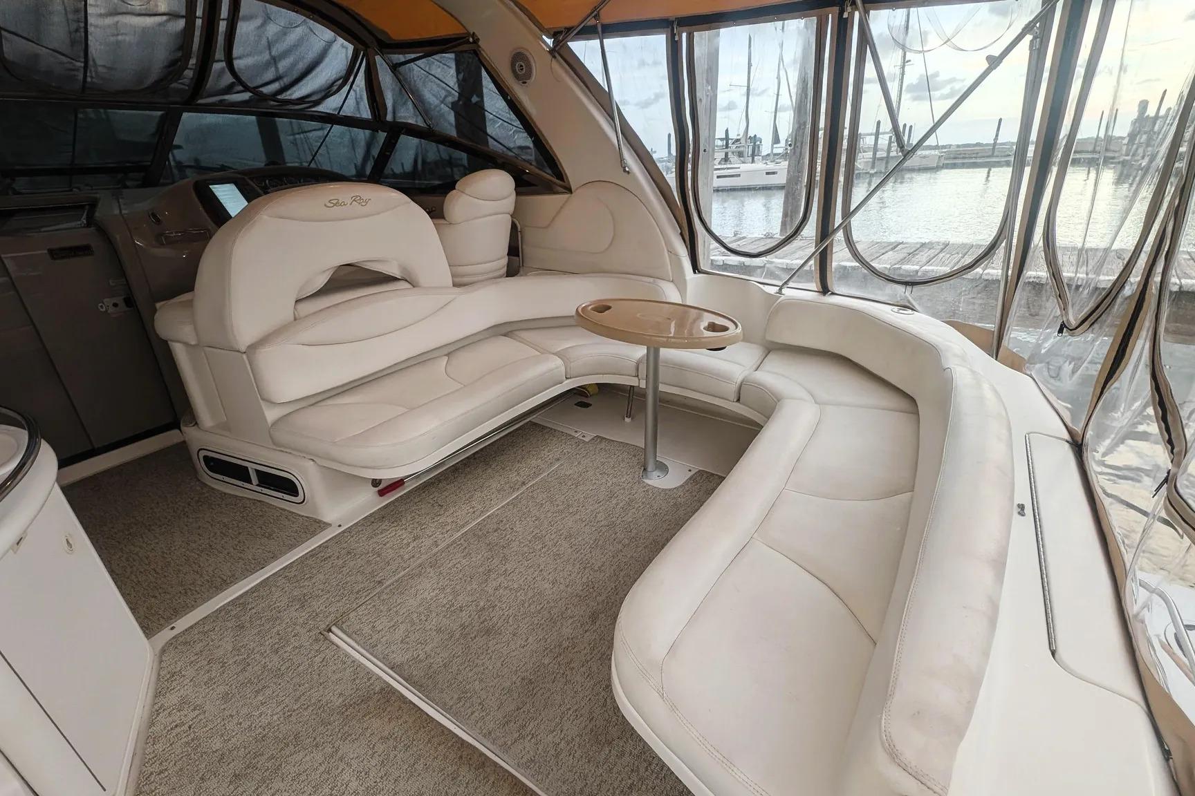Luxurious interior of a 2000 Sea Ray 380 Sundancer yacht with plush seating and table.