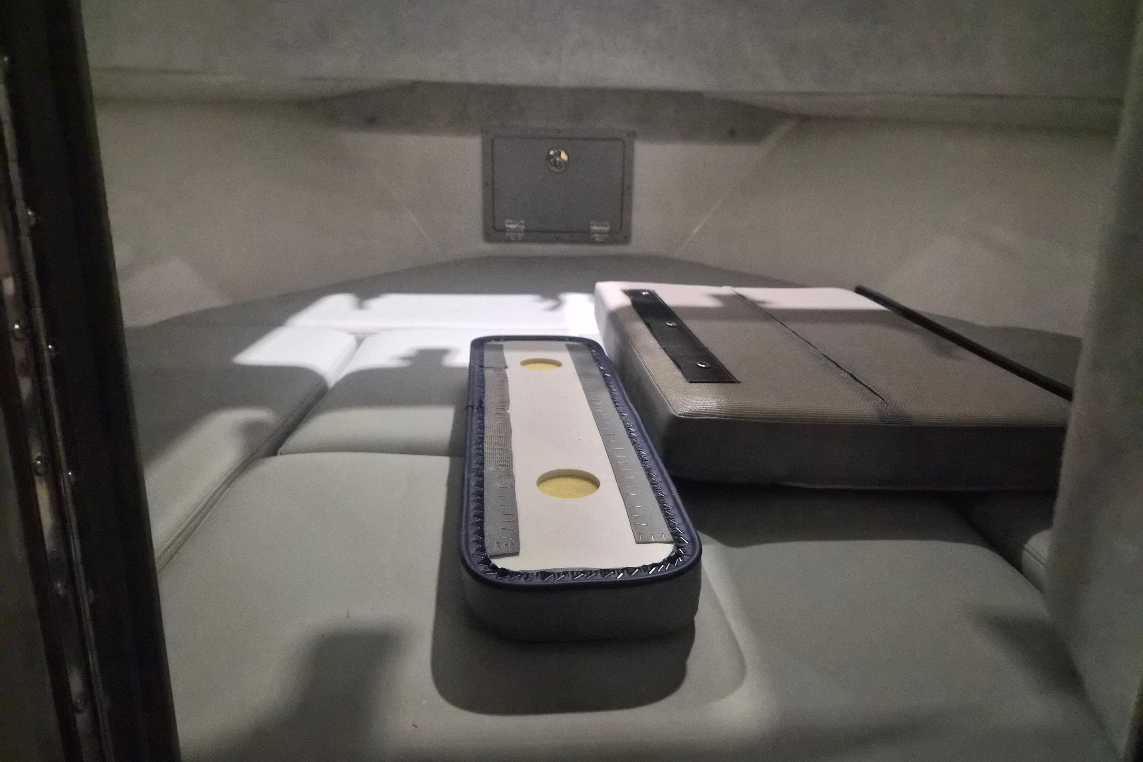Interior cabin of 2026 Defiance Admiral 260 EX boat, featuring cushioned seating and storage.