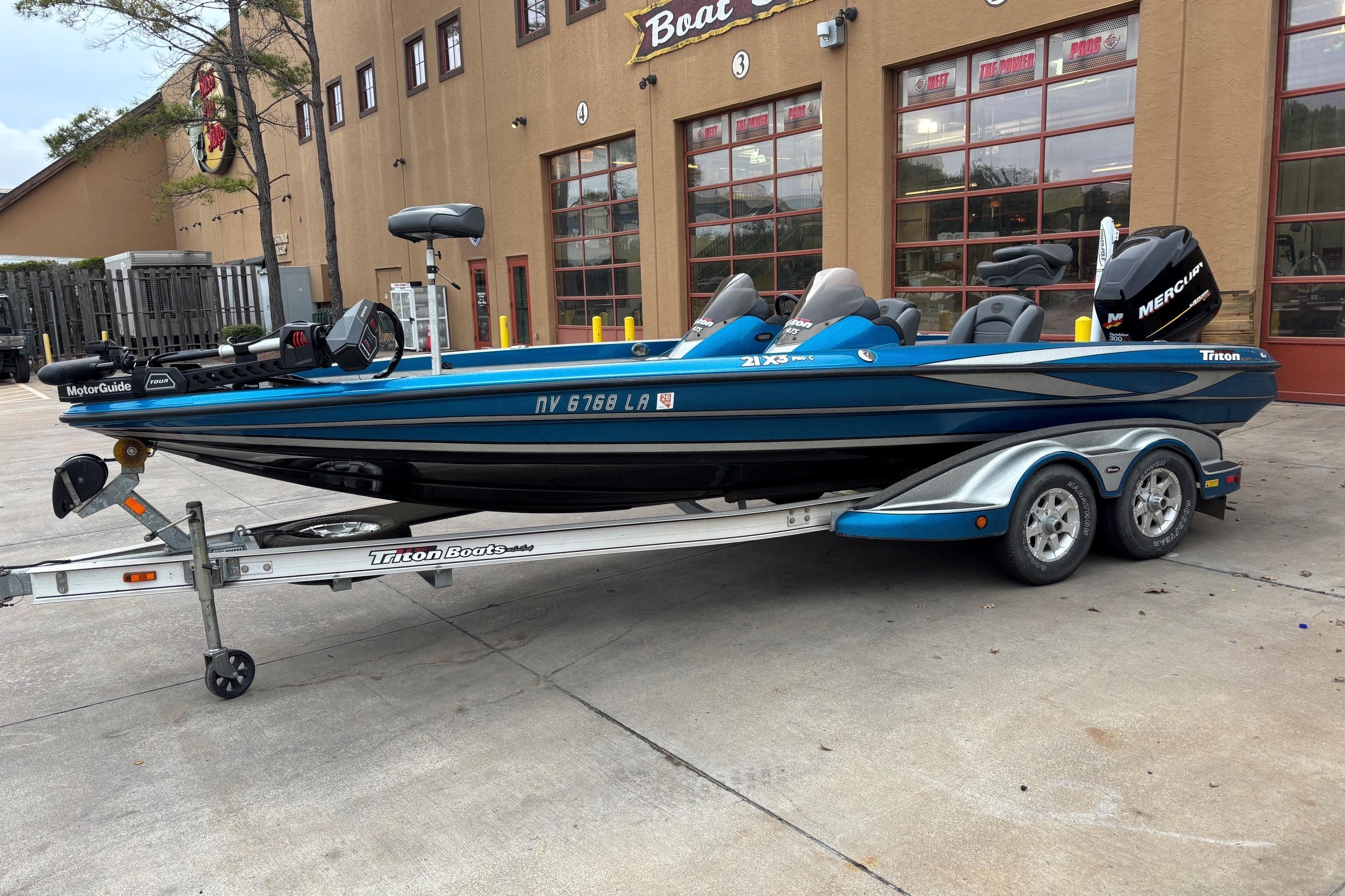 2009 Triton 22 TrX boat on trailer, parked outside a building.