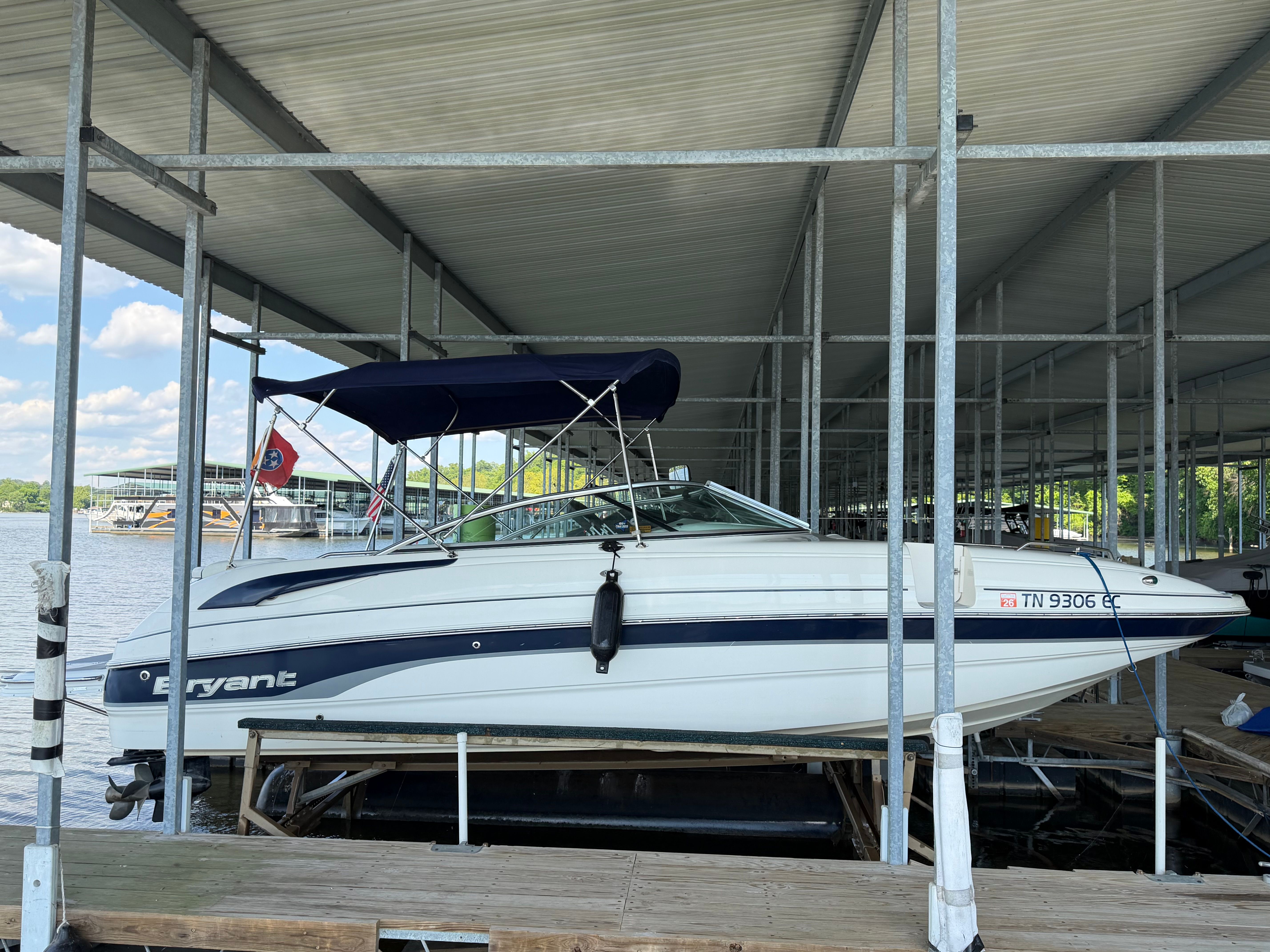 2010 Bryant 255 boat docked with blue canopy.