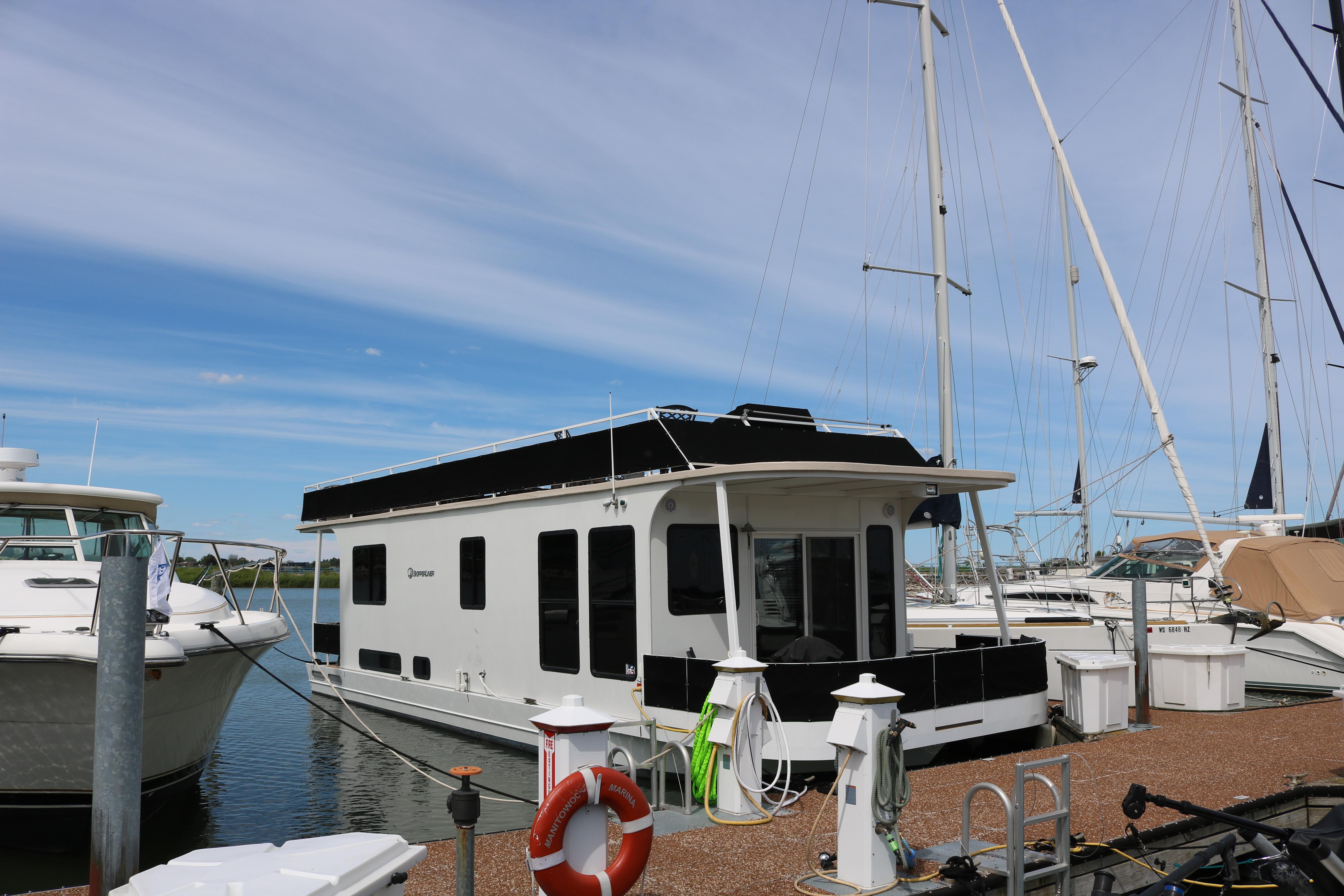 2010 Skipperliner 480 Flybridge docked at marina, surrounded by sailboats under a clear sky.