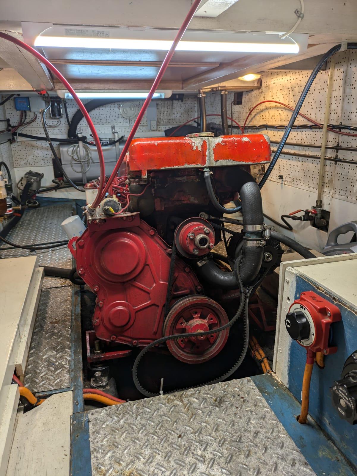 Engine room of 1984 Island Trader 40 with red engine and visible wiring.