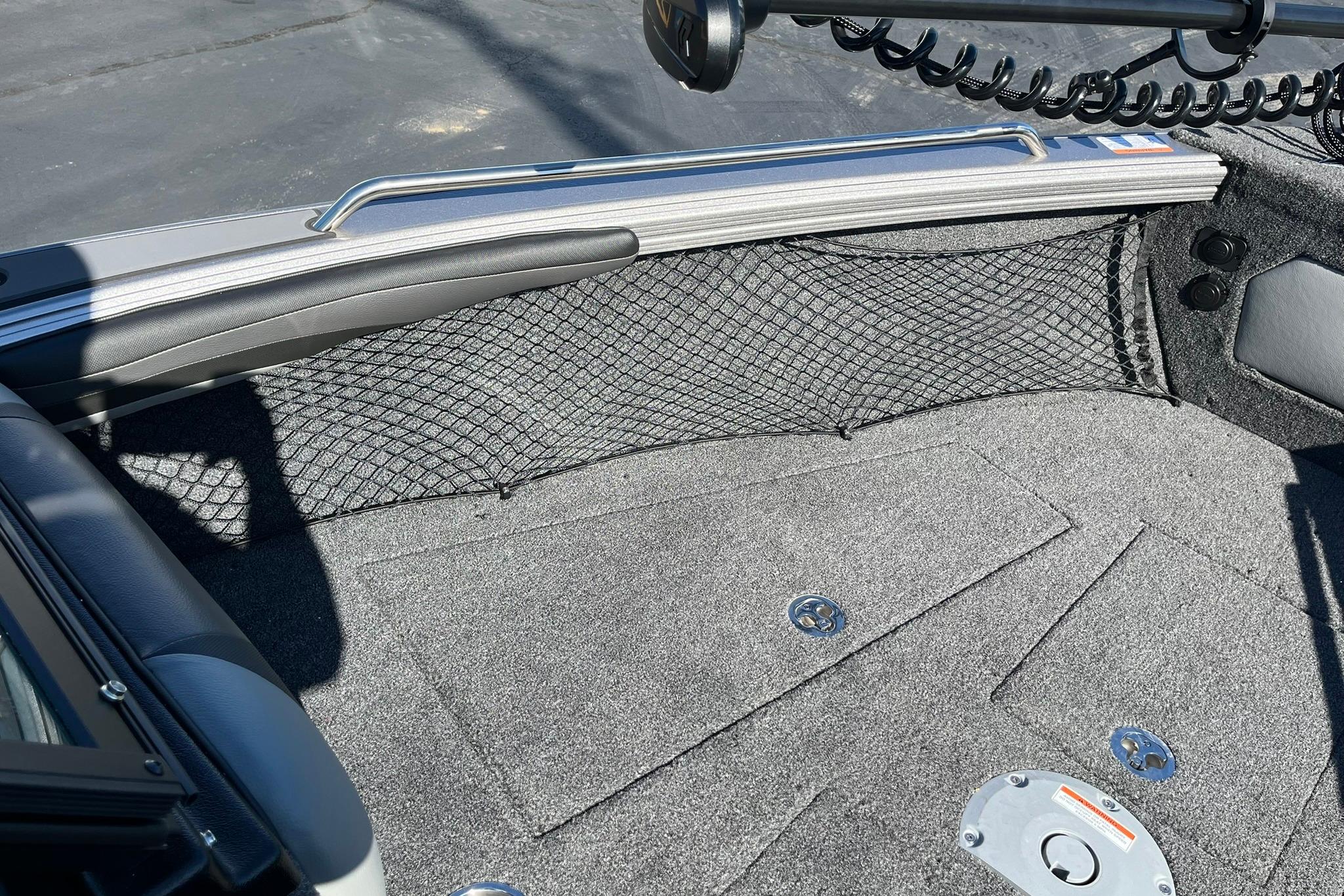 2026 Lund 2275 Baron boat interior with carpeted flooring and storage netting.