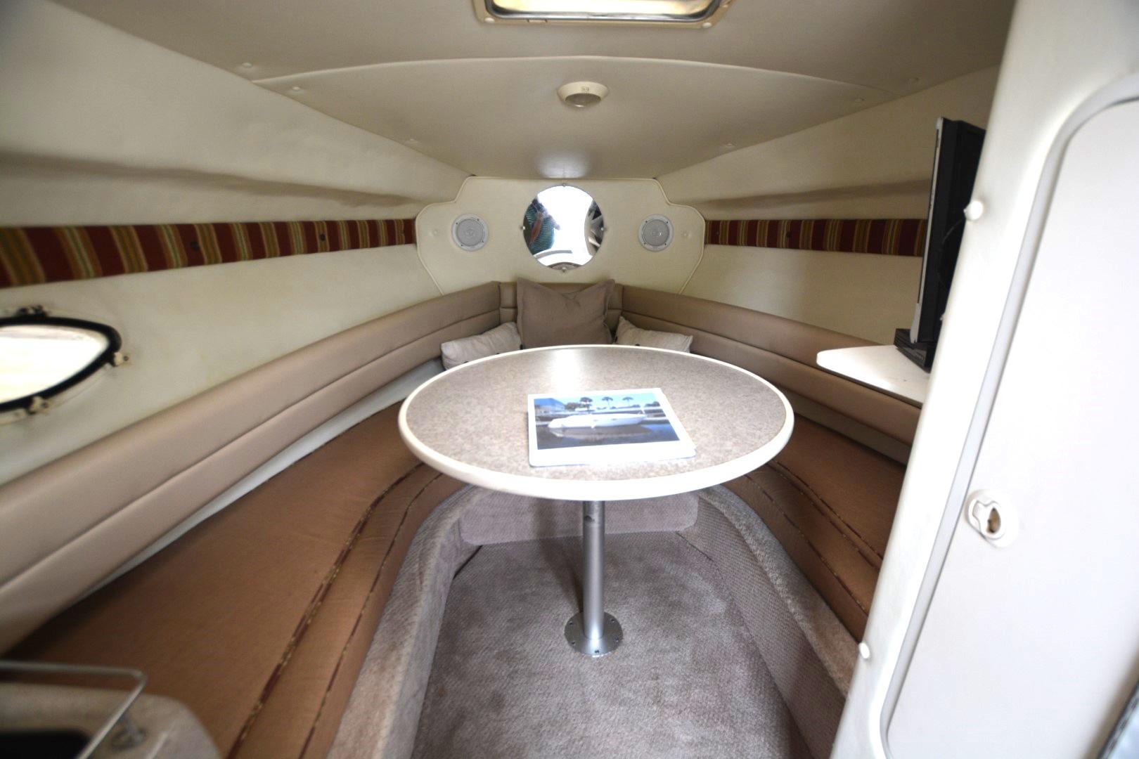 1999 Rinker 270 Fiesta Vee cabin interior with table and seating area.