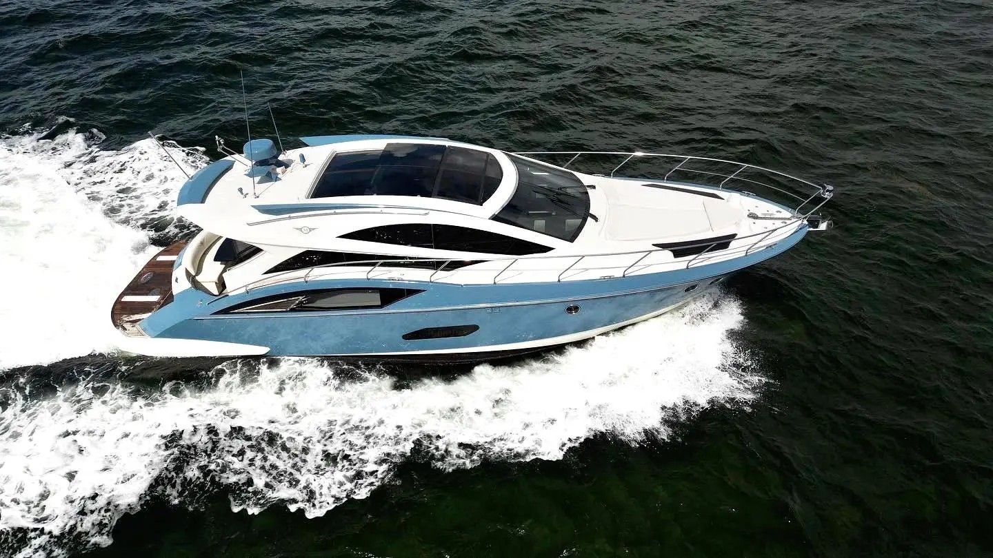 2010 Marquis Sport Coupe on the water, sleek design, blue and white paint.