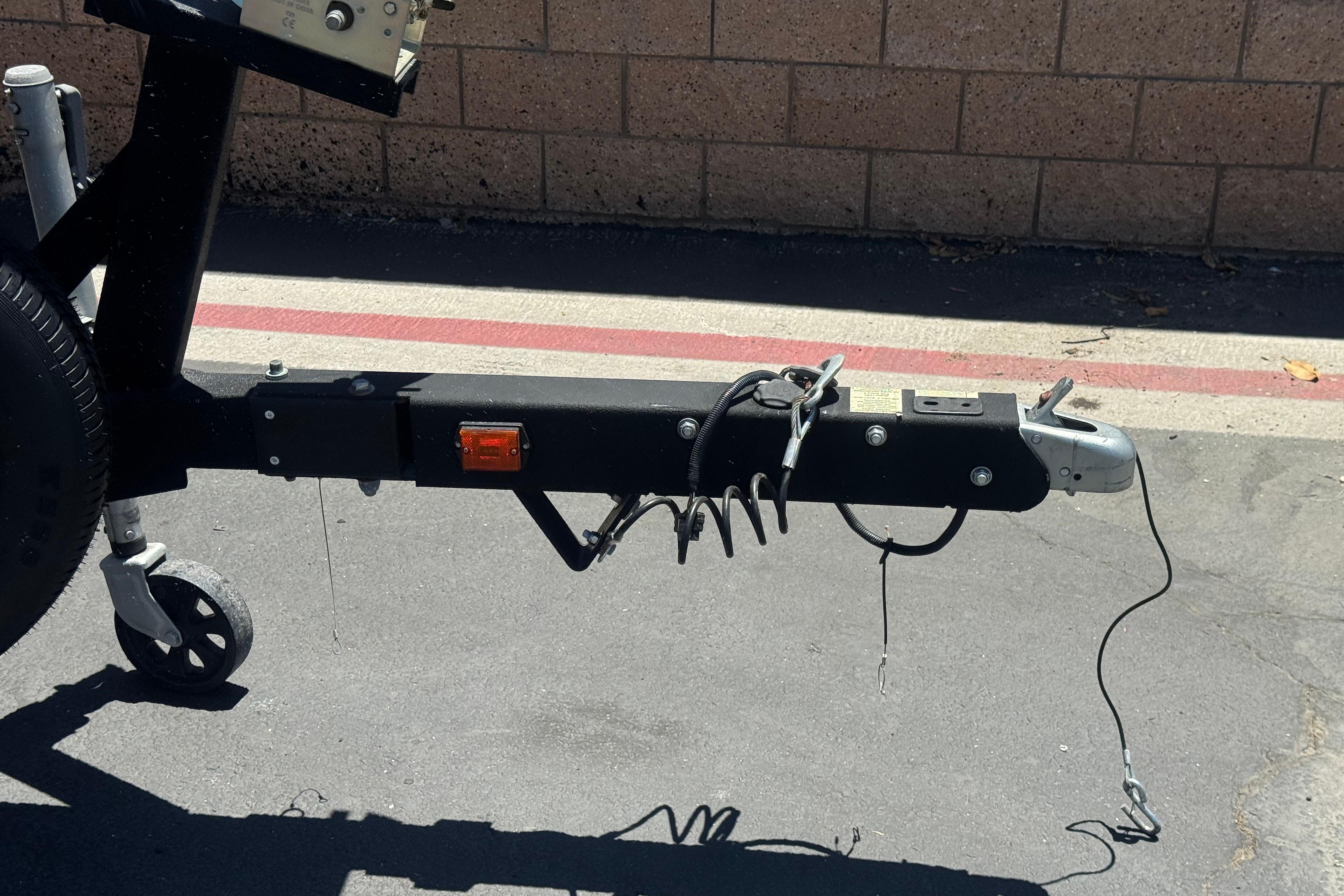 Trailer hitch of a 2022 Four Winns H4 boat on pavement.
