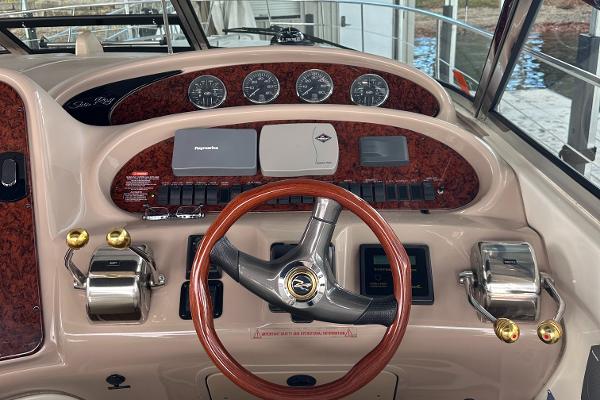 Dashboard of 2004 Sea Ray 380 Sundancer with wood accents and steering wheel.