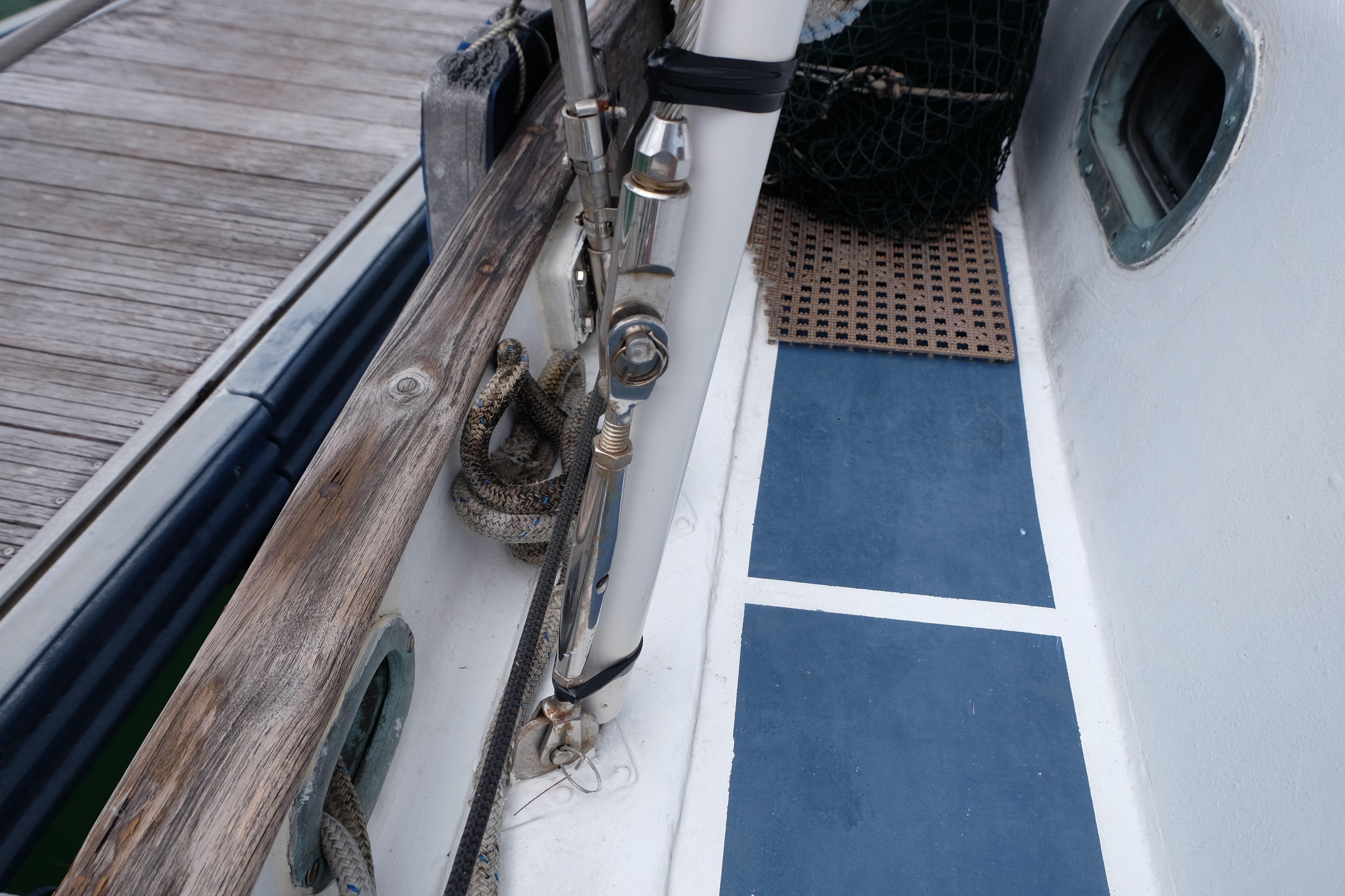 Close-up of 1979 Westwind 35 sailboat deck with ropes and wooden railing.