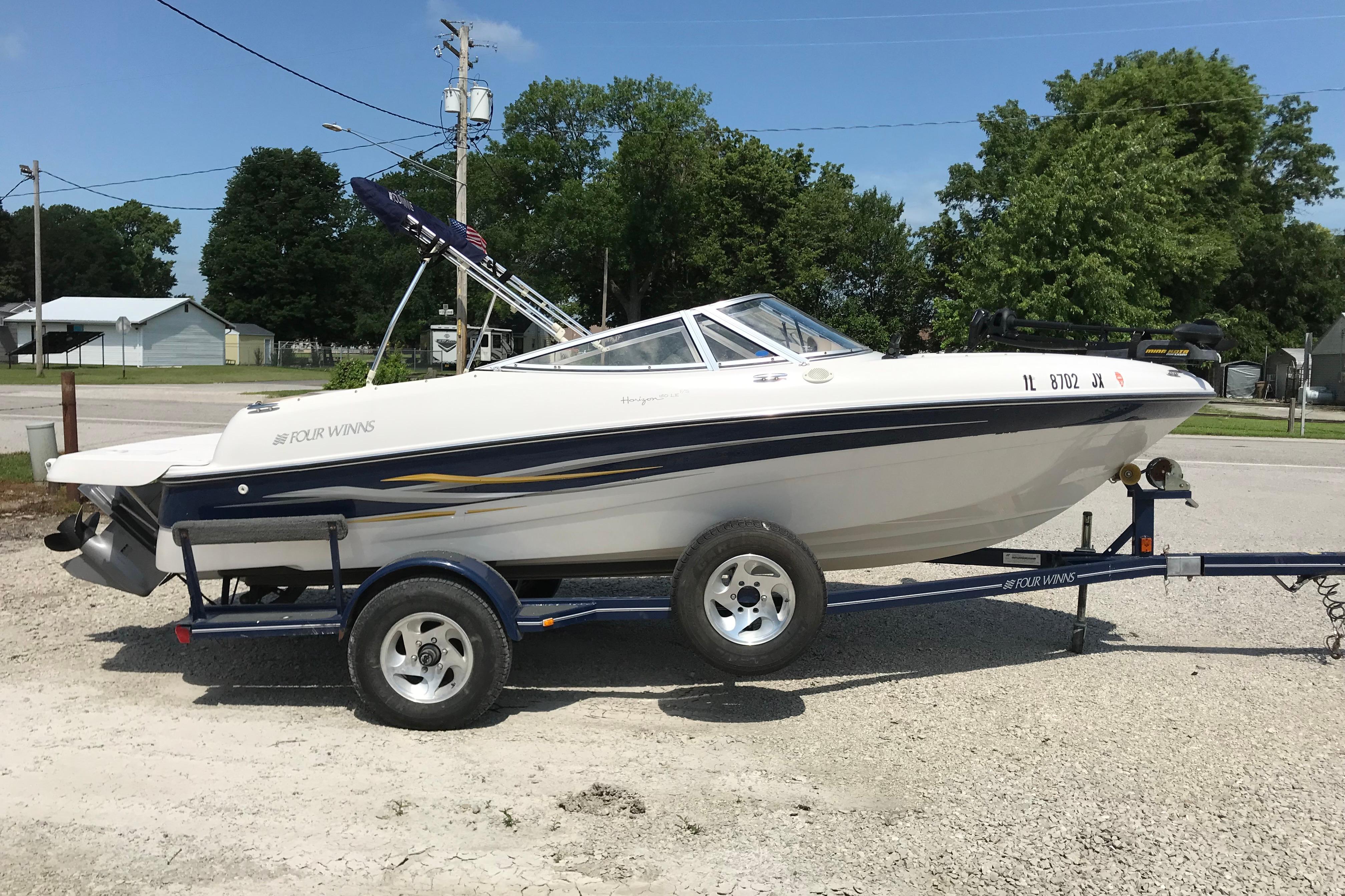 2005 Four Winns 180 Horizon FS boat on trailer, parked outdoors.