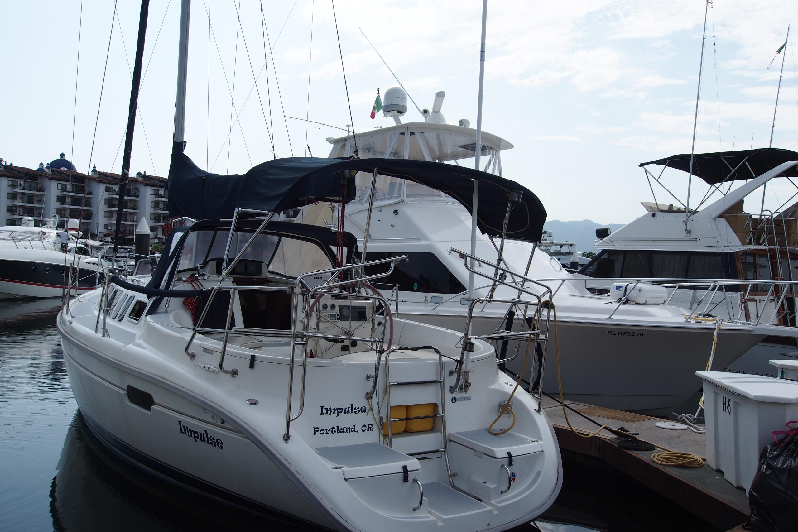 Sailboat "Impulse," Hunter 336, 1995 model, docked in a marina with other boats.