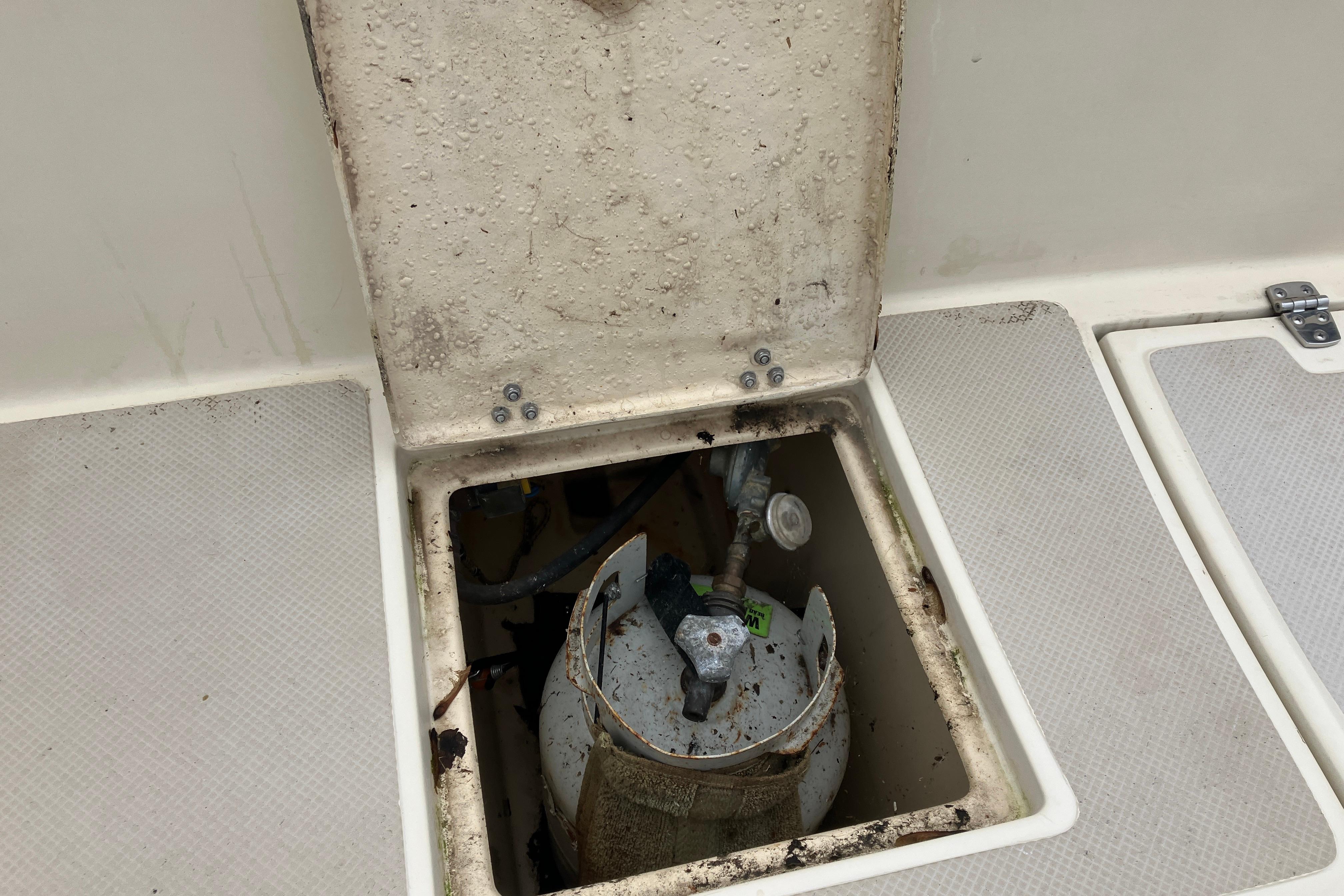 Open hatch on 1990 Island Packet 32 Cutter revealing storage compartment.