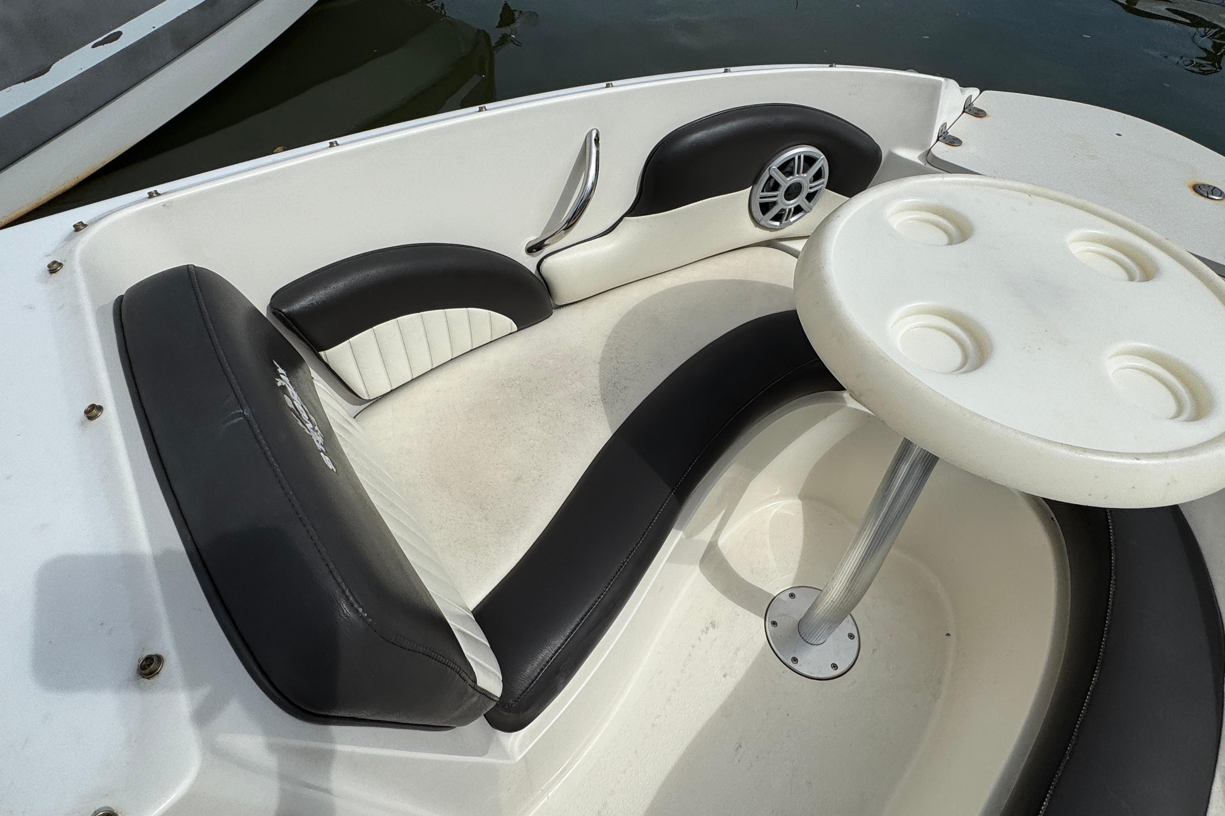 2018 Stingray 204 LR boat interior with black and white seating and round table.