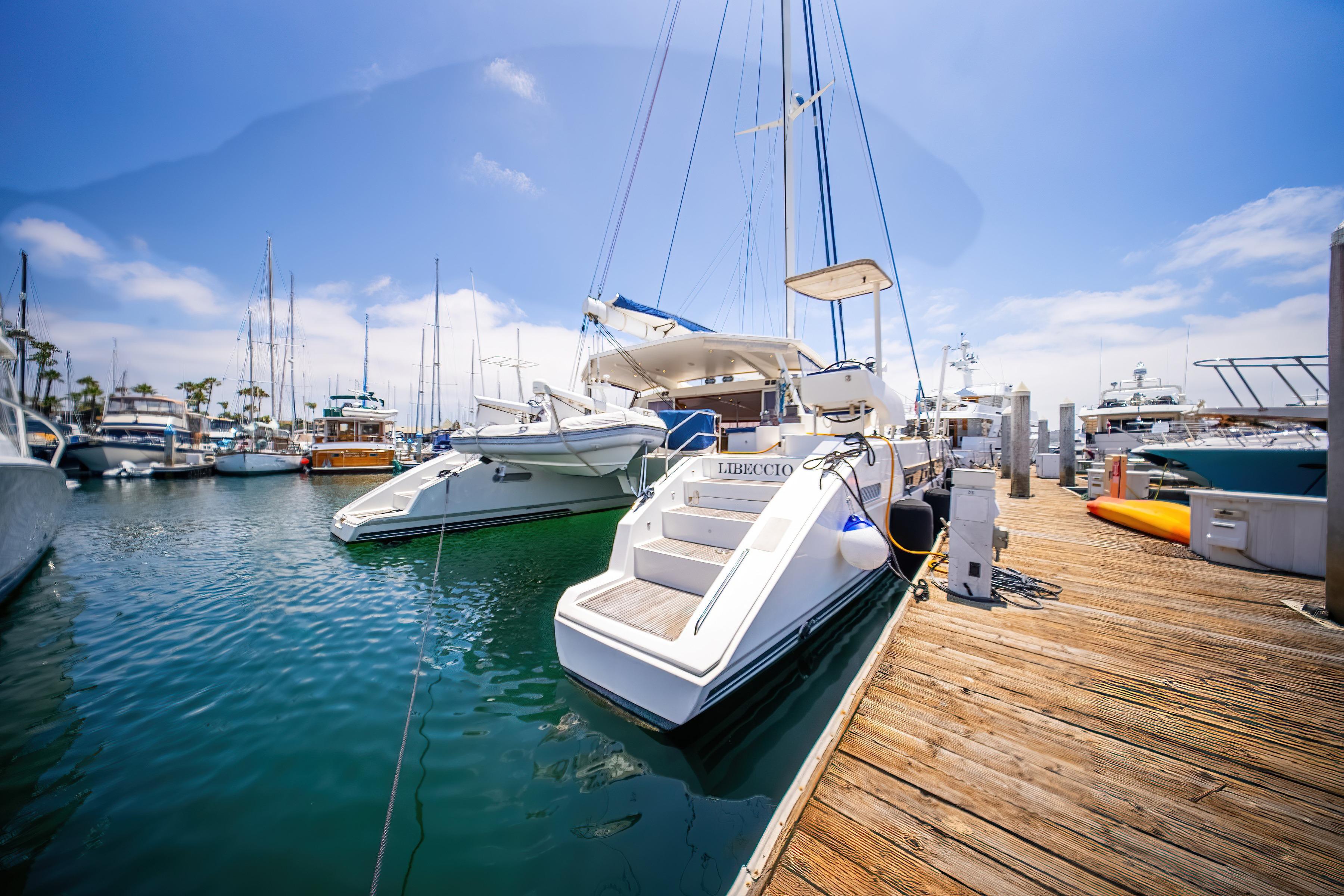 2009 Catana 65 yacht docked at marina under clear blue sky.