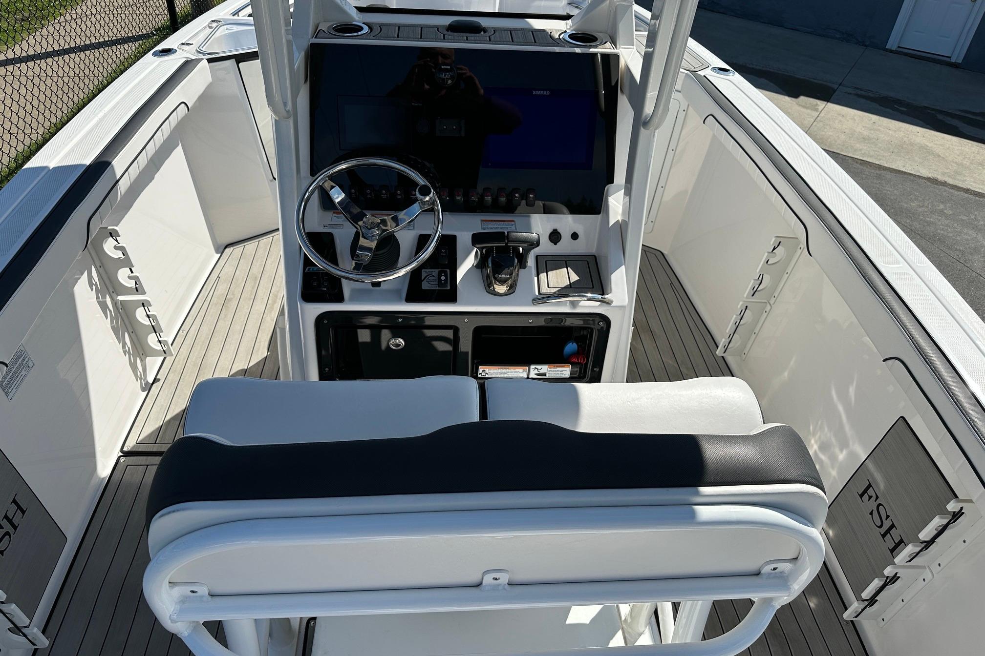 2022 Yamaha Boats 255 FSH Sport E cockpit with steering wheel and controls.