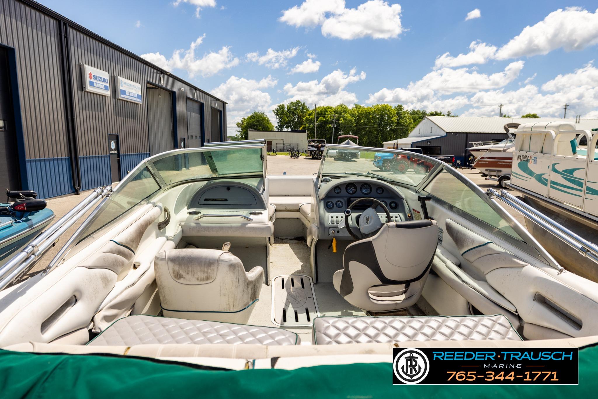 1996 Sea Ray 210 Bow Rider boat interior at marina, featuring steering wheel and seating.