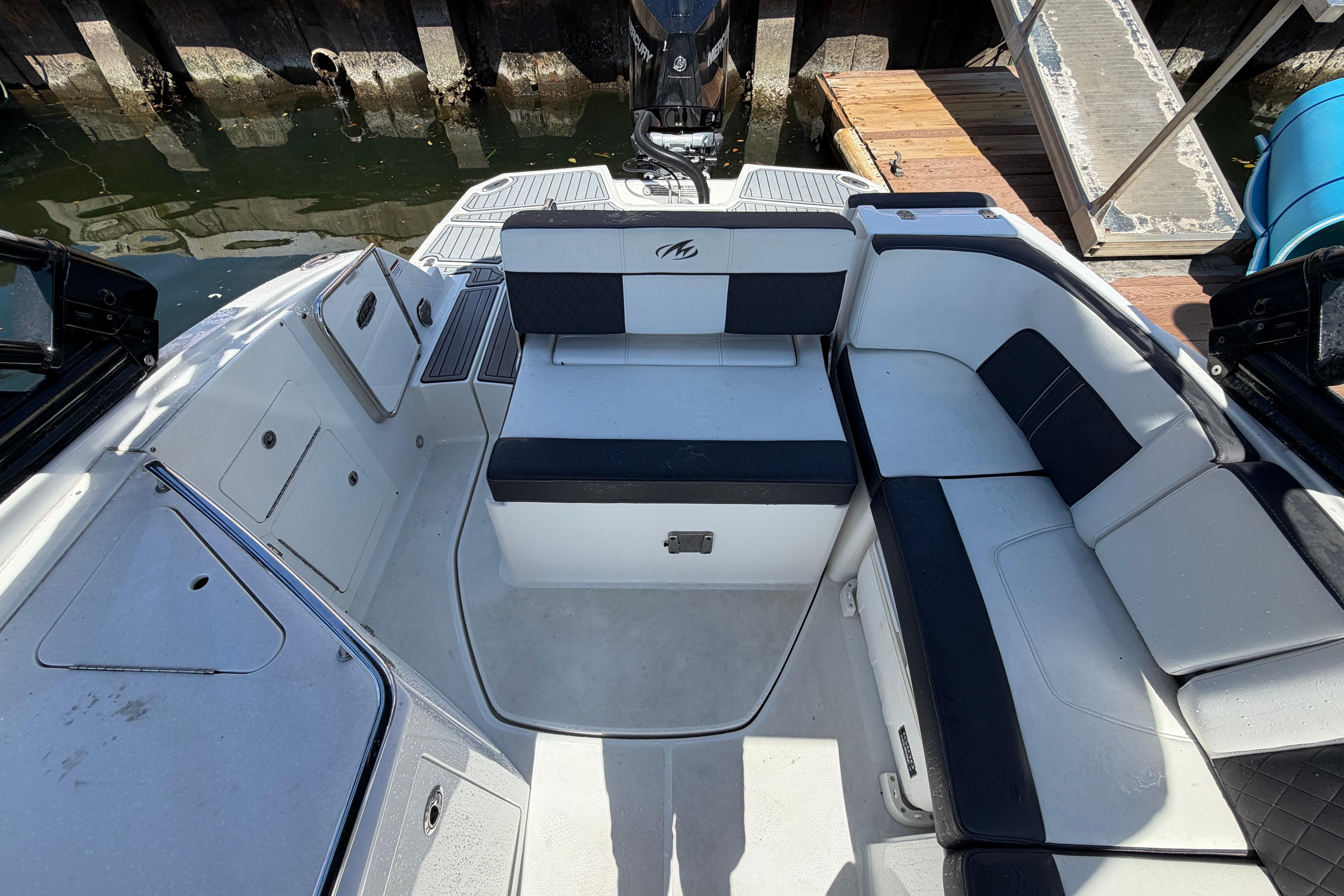 2022 Monterey M-65 boat interior with white and black seating, docked by the water.