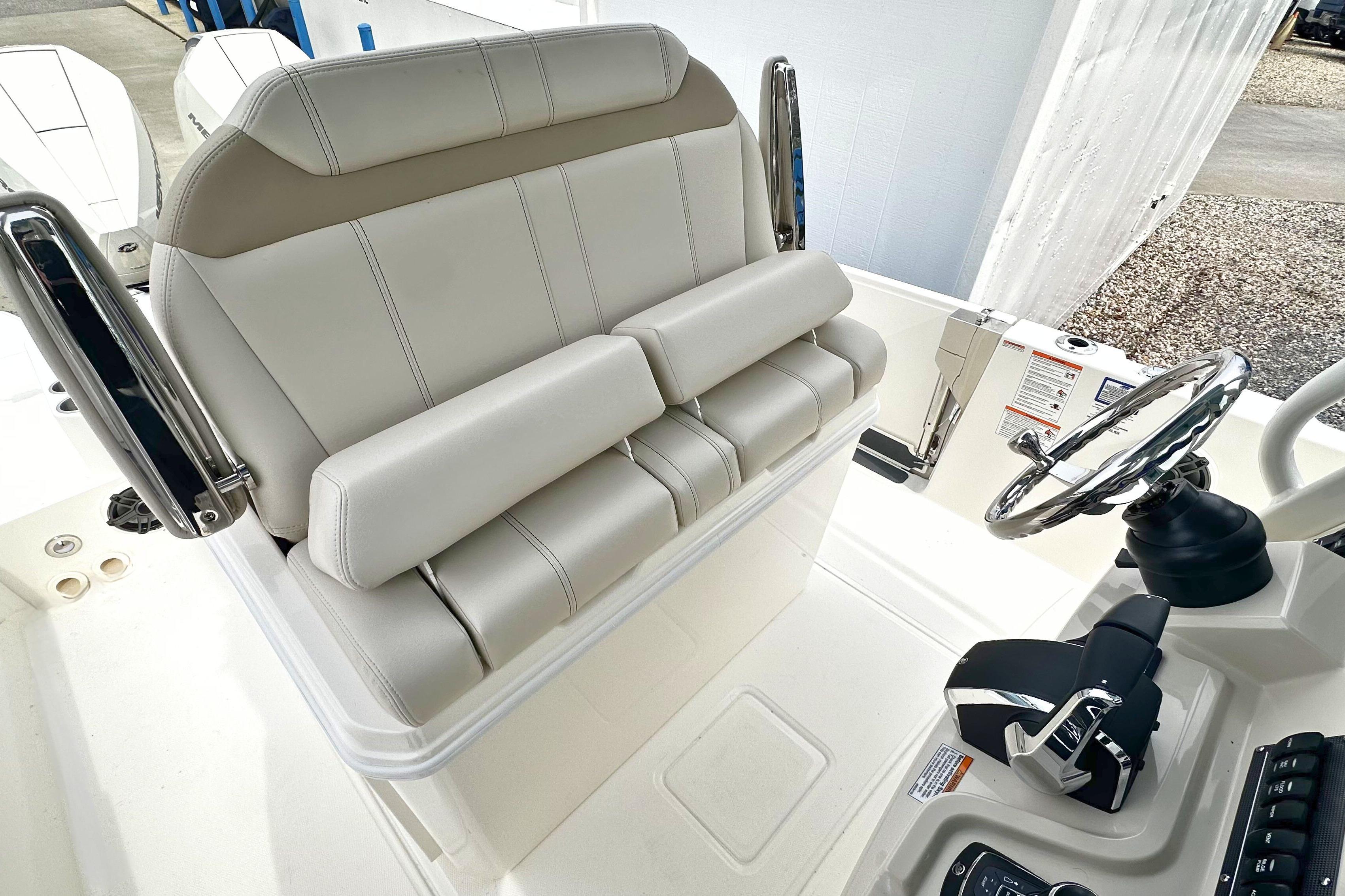 2026 Boston Whaler 280 Dauntless helm with cushioned seating and steering wheel.