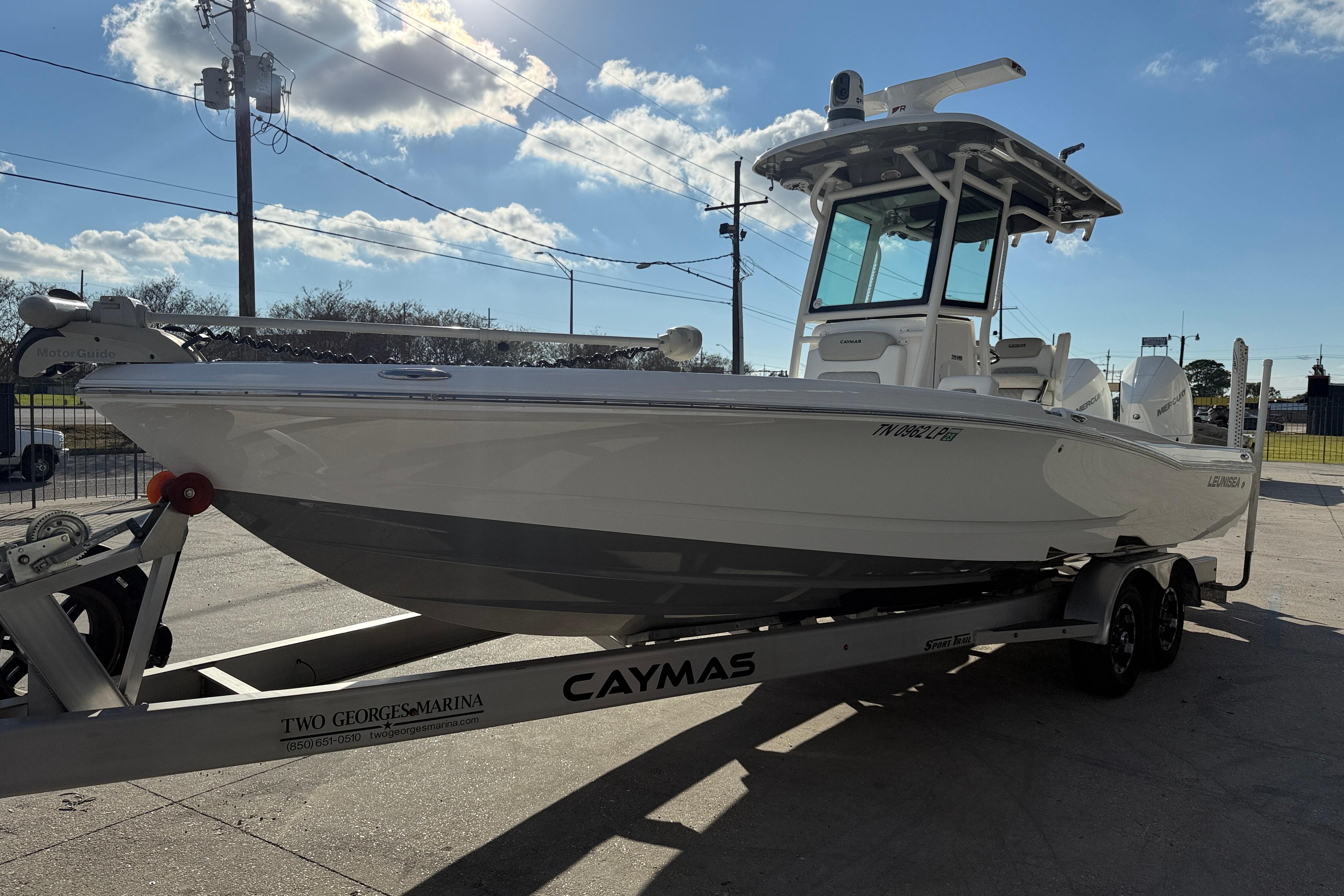 2022 Caymas 28 HB Twin boat on trailer under clear sky.