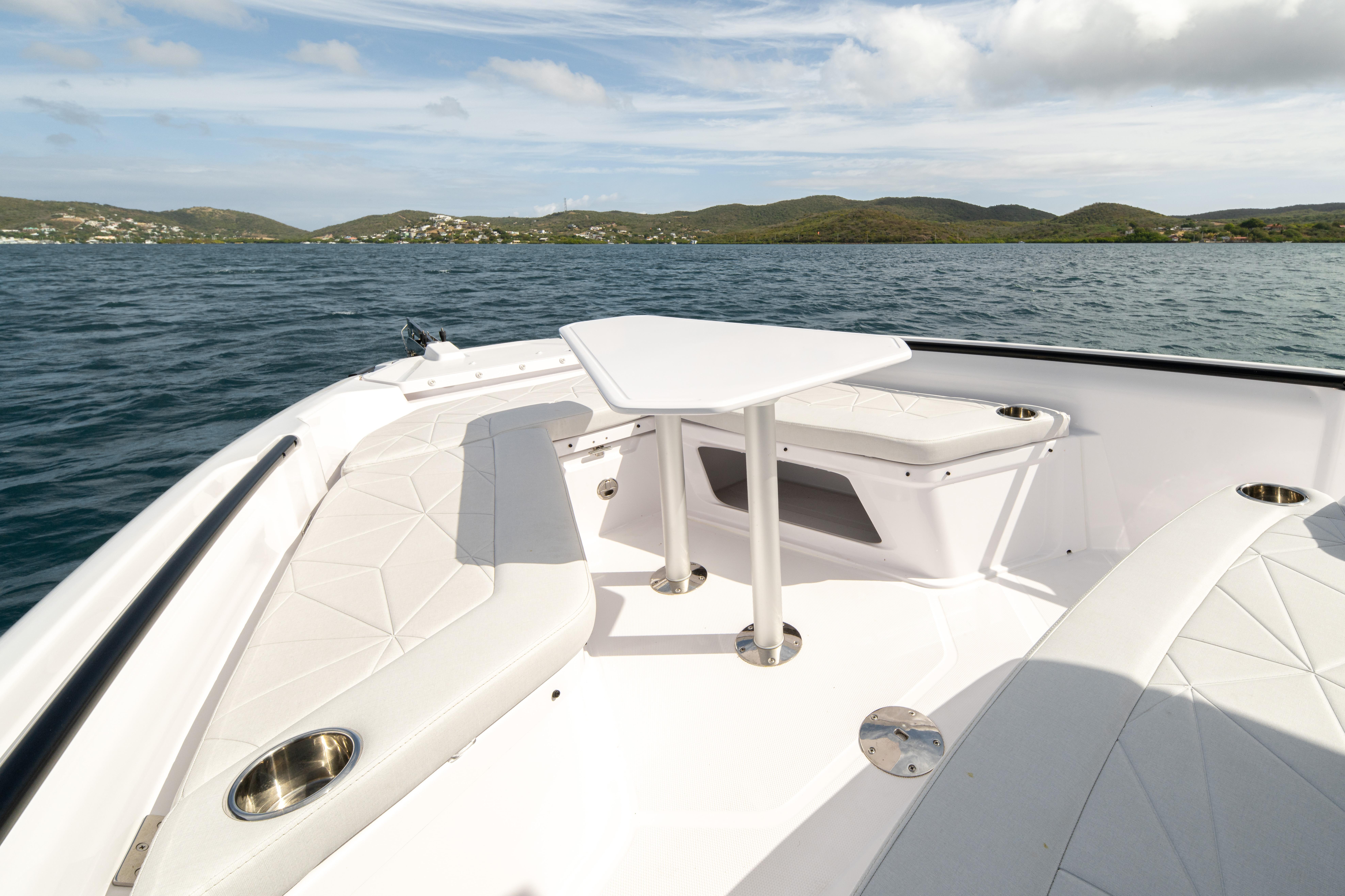 2025 Axopar 29 CCX boat interior with seating and table on calm water.