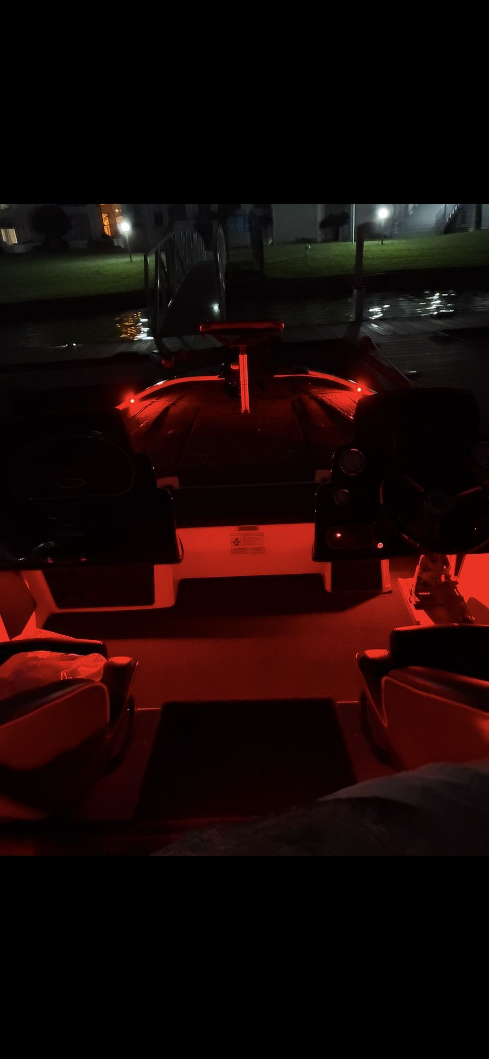 A boat dock illuminated at night with red lights.