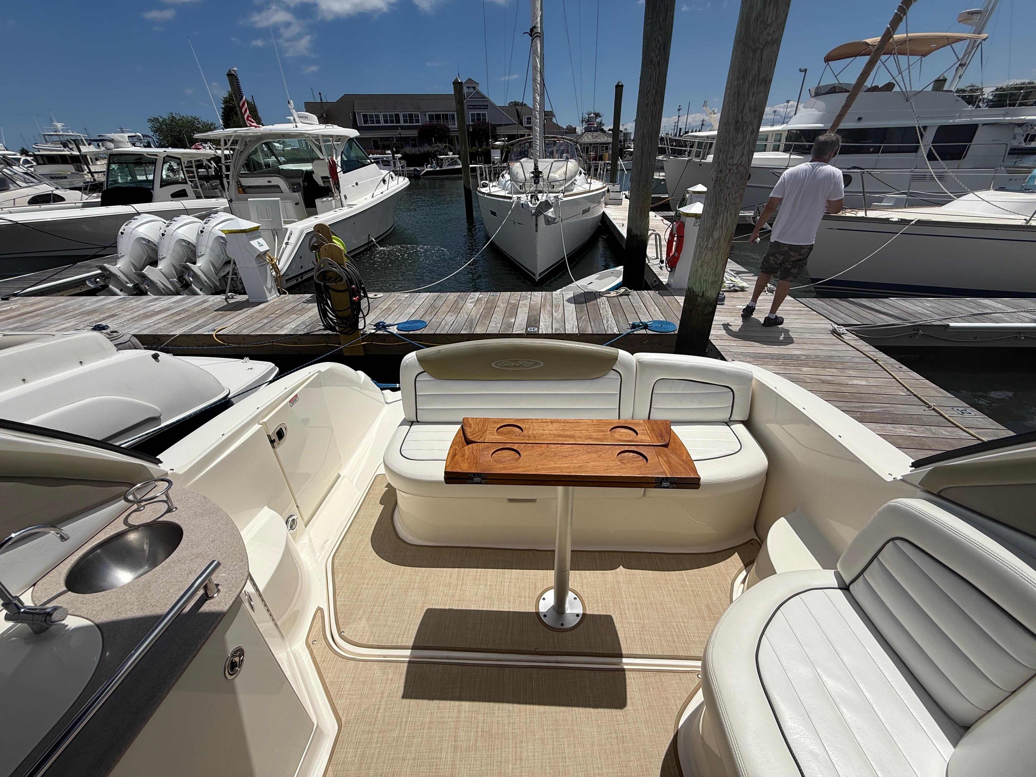 2006 Sea Ray 290 Sundancer interior with seating and table at marina dock.