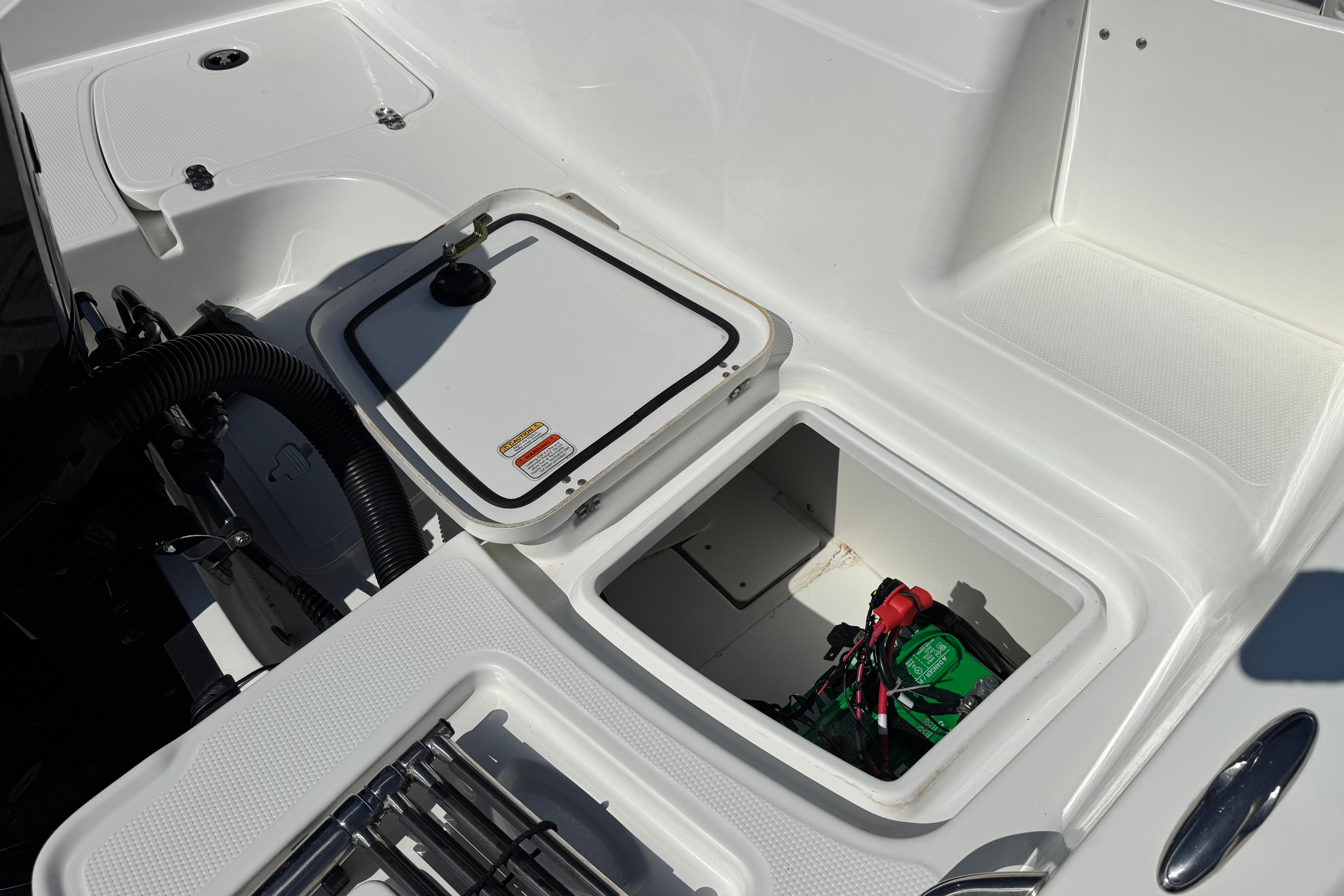 2019 Tahoe 2150 boat storage compartment with open hatch and visible battery.