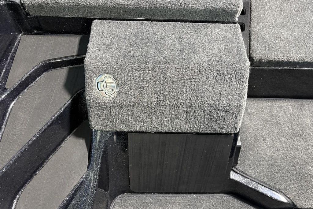 Carpeted interior detail of a 2026 Skeeter ZXE21 boat, featuring a metal latch.