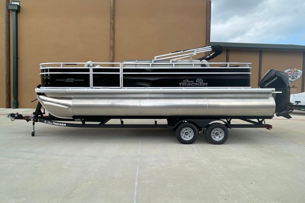 2026 Sun Tracker Fishin' Barge 22 XP3 pontoon boat on trailer, side view.
